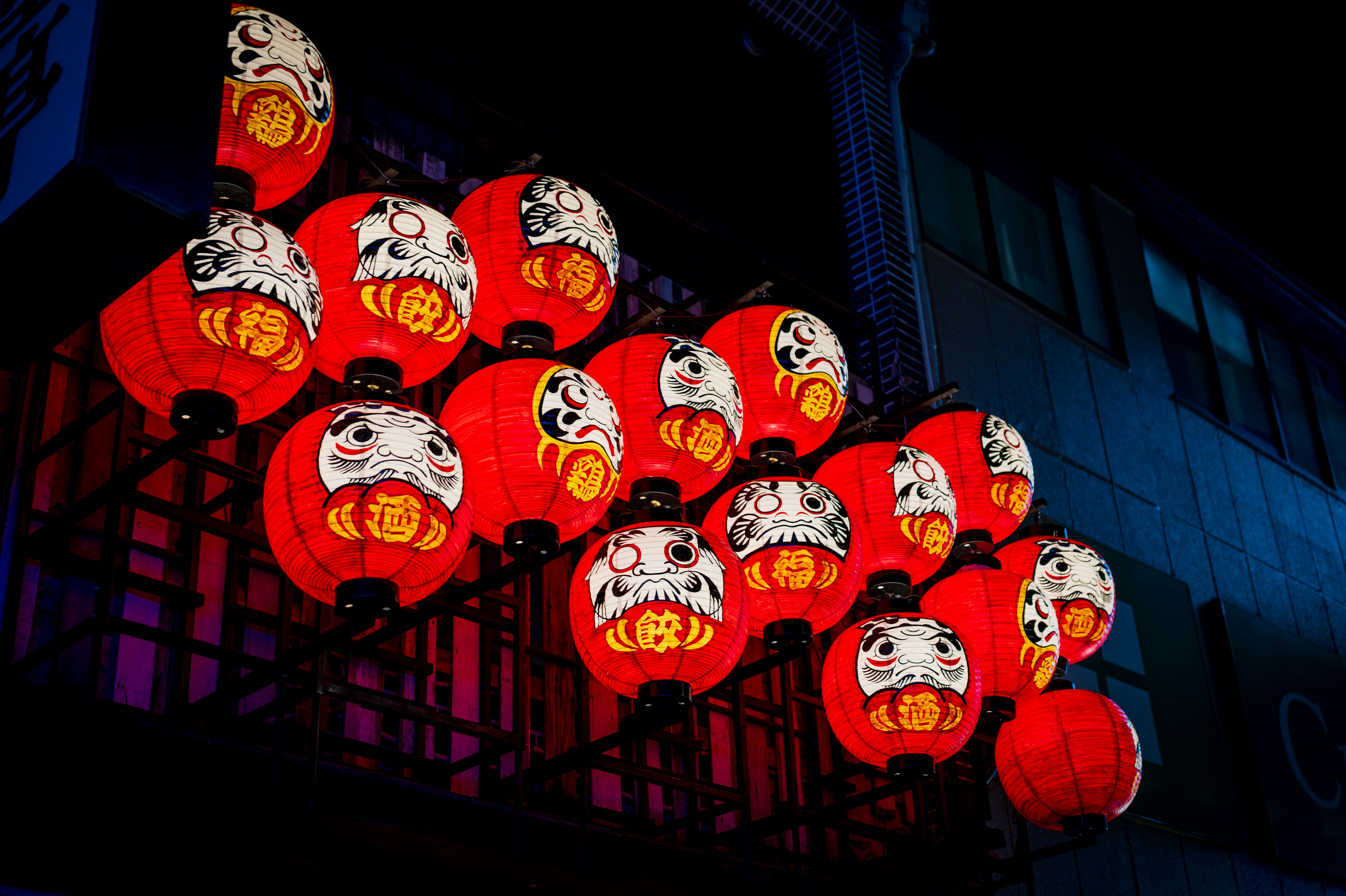 Red daruma dolls hanging at night