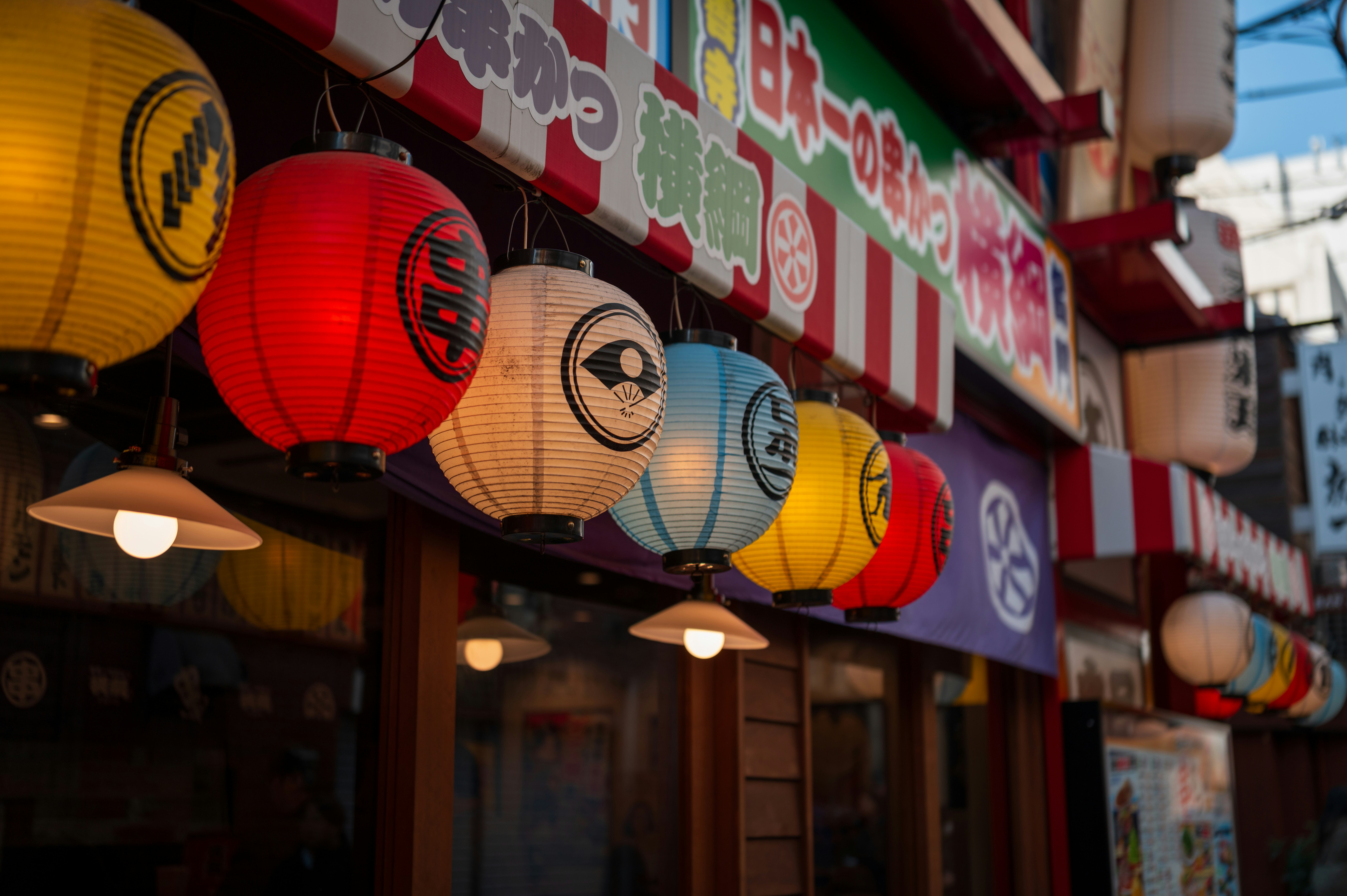 Colorful japanese lanterns hanging outside a shop