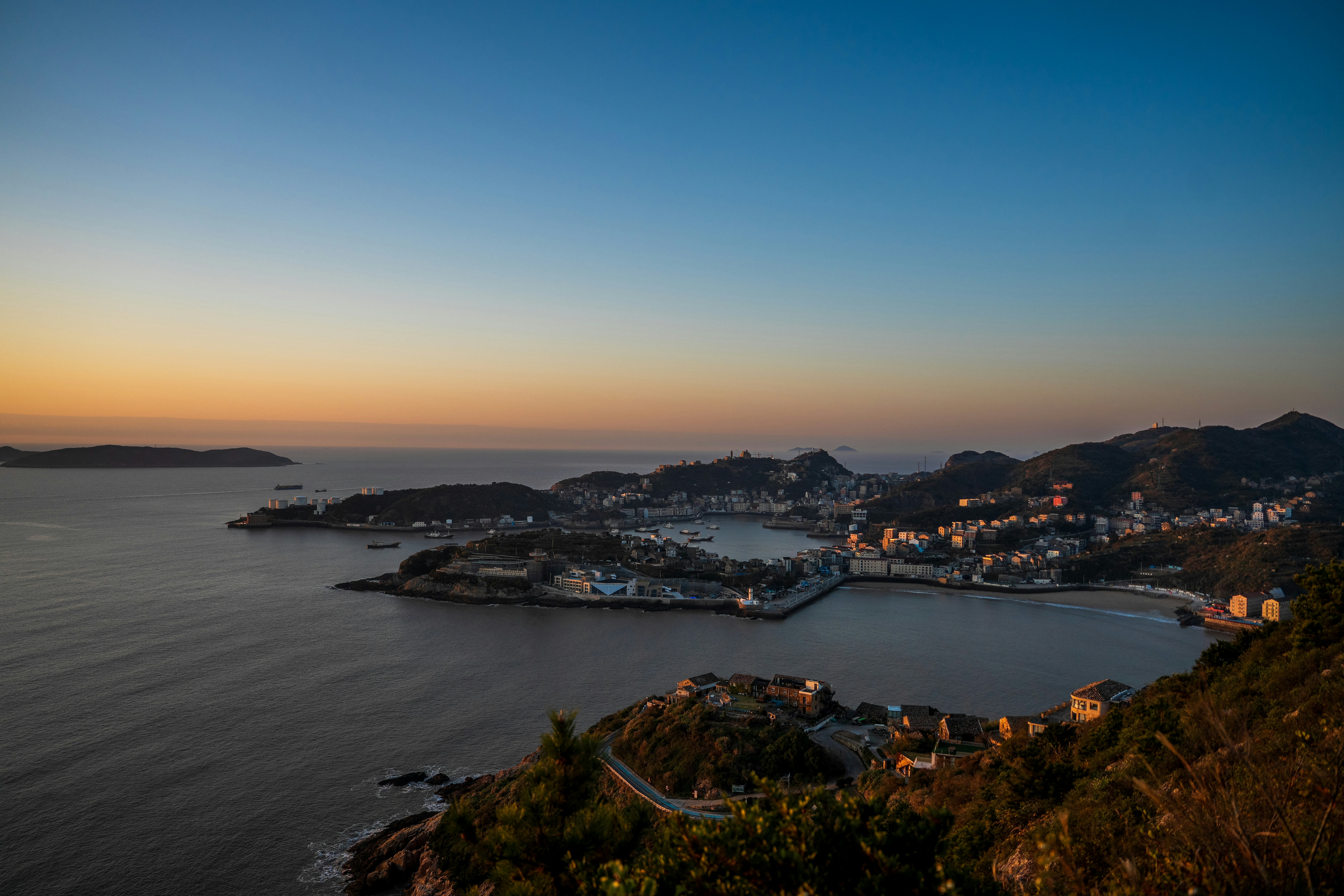 Skyline der Küstenstadt bei Einbruch der Dämmerung mit Blick auf das Meer.