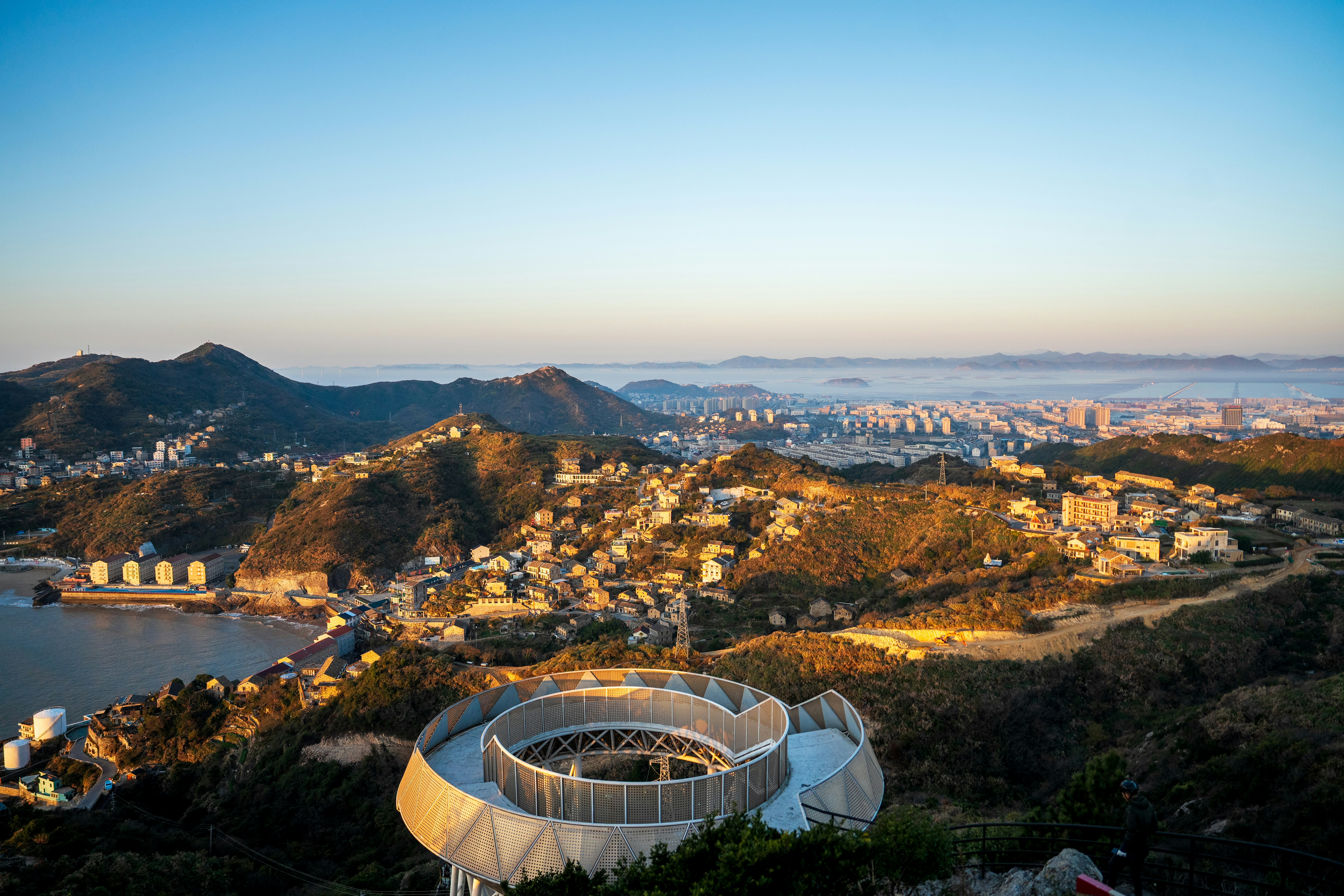 Der moderne Spiralweg überblickt die Küstenstadt und Hügel.