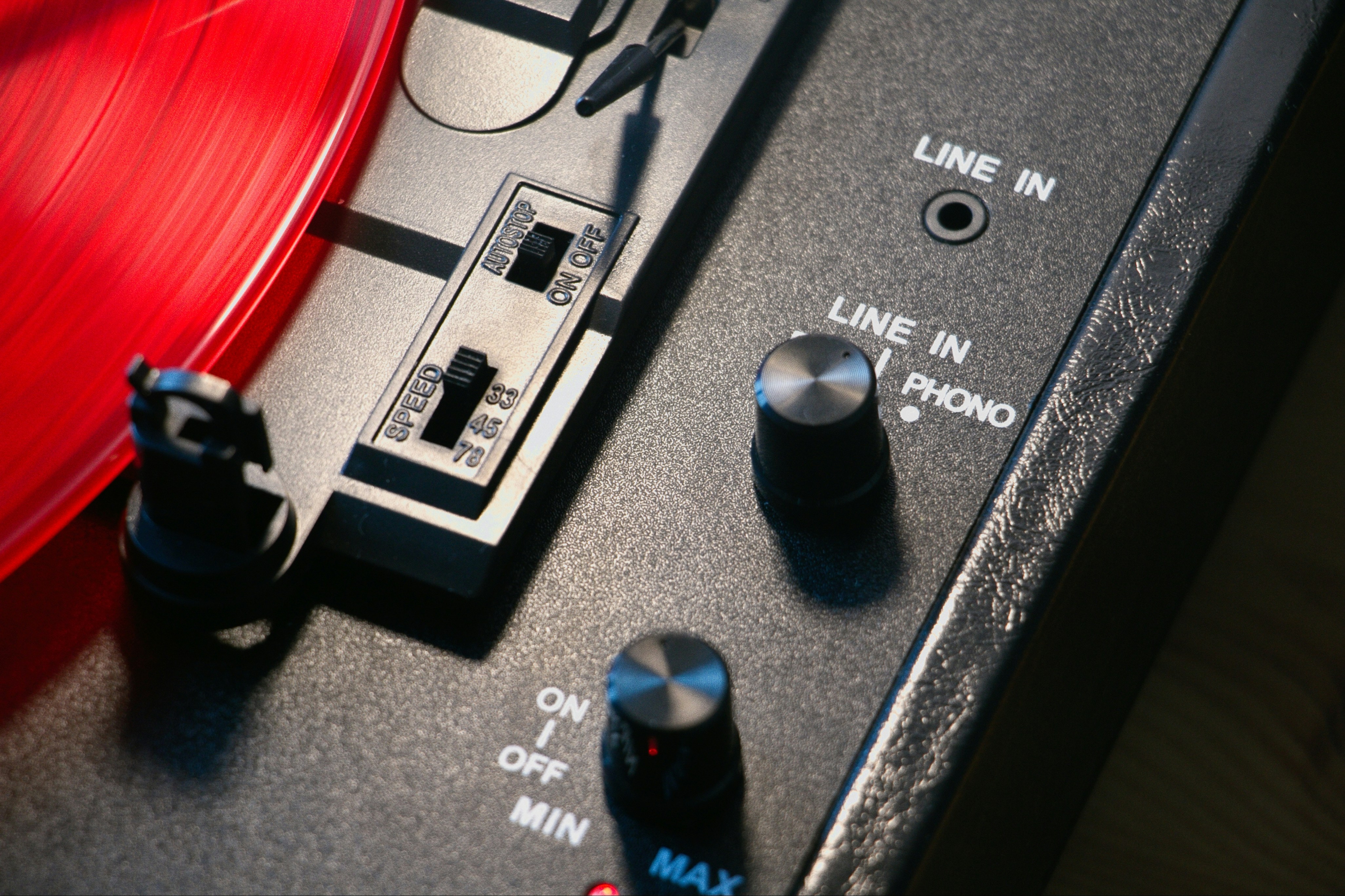 Close-up of a red vinyl record on a turntable.