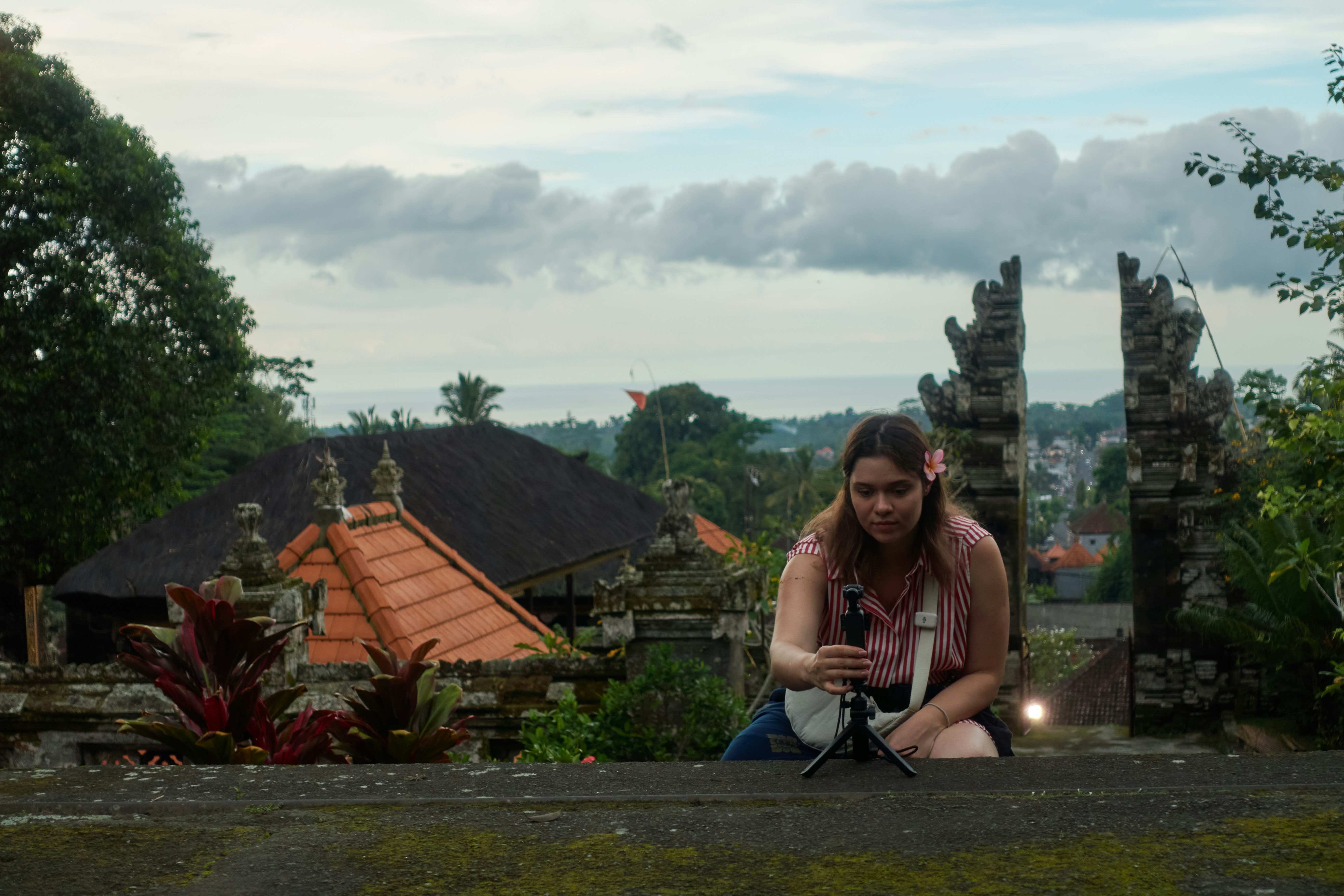 Woman filming with a tripod in a temple.