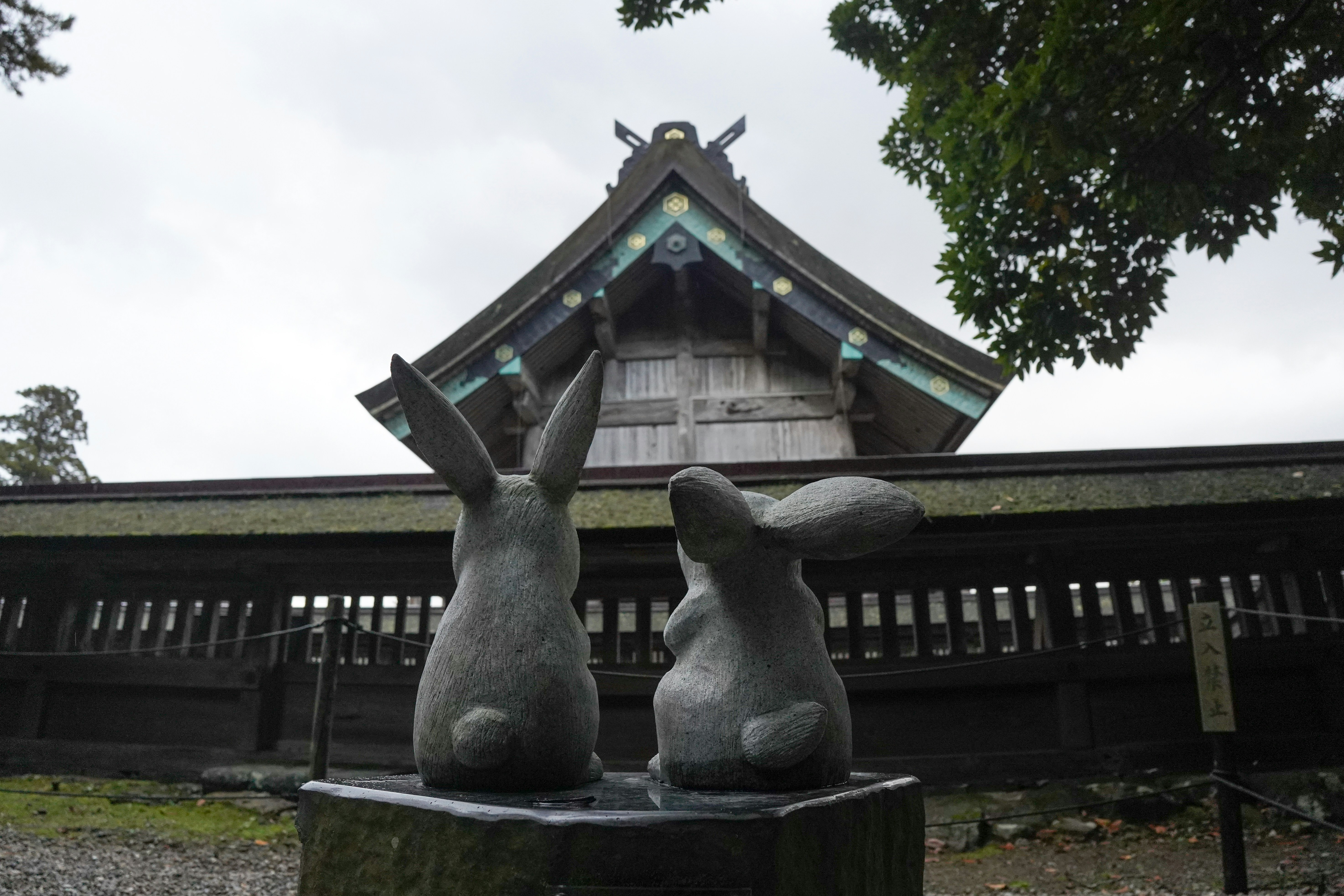 Two stone rabbit statues in front of a temple