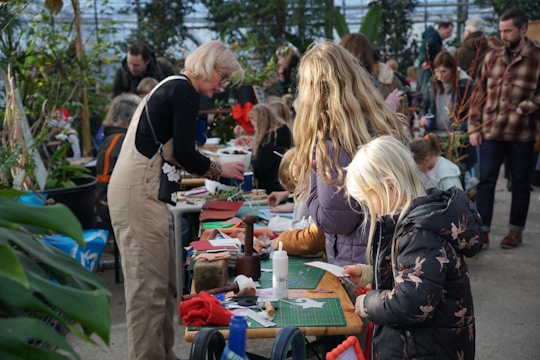 Adults and children crafting at tables with plants