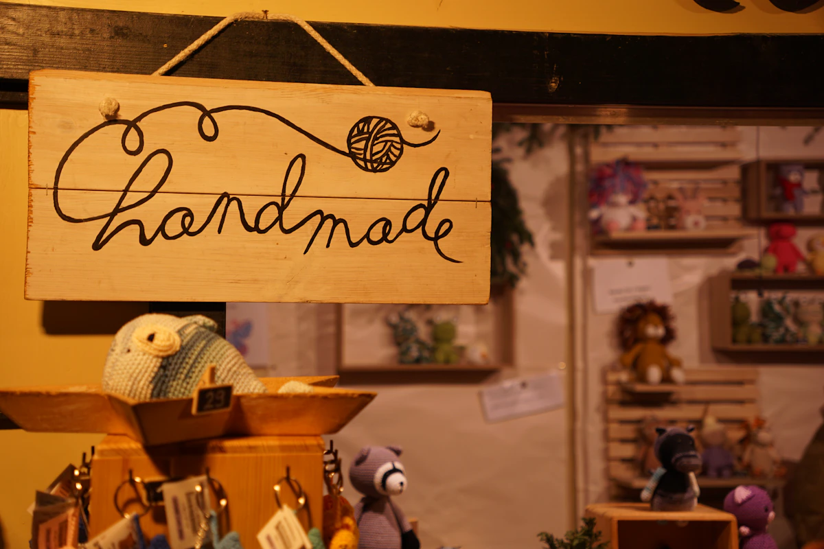Panneau en bois portant le mot handmade sur un stand de marché de créateurs