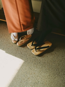 Two pairs of traditional japanese footwear on concrete.