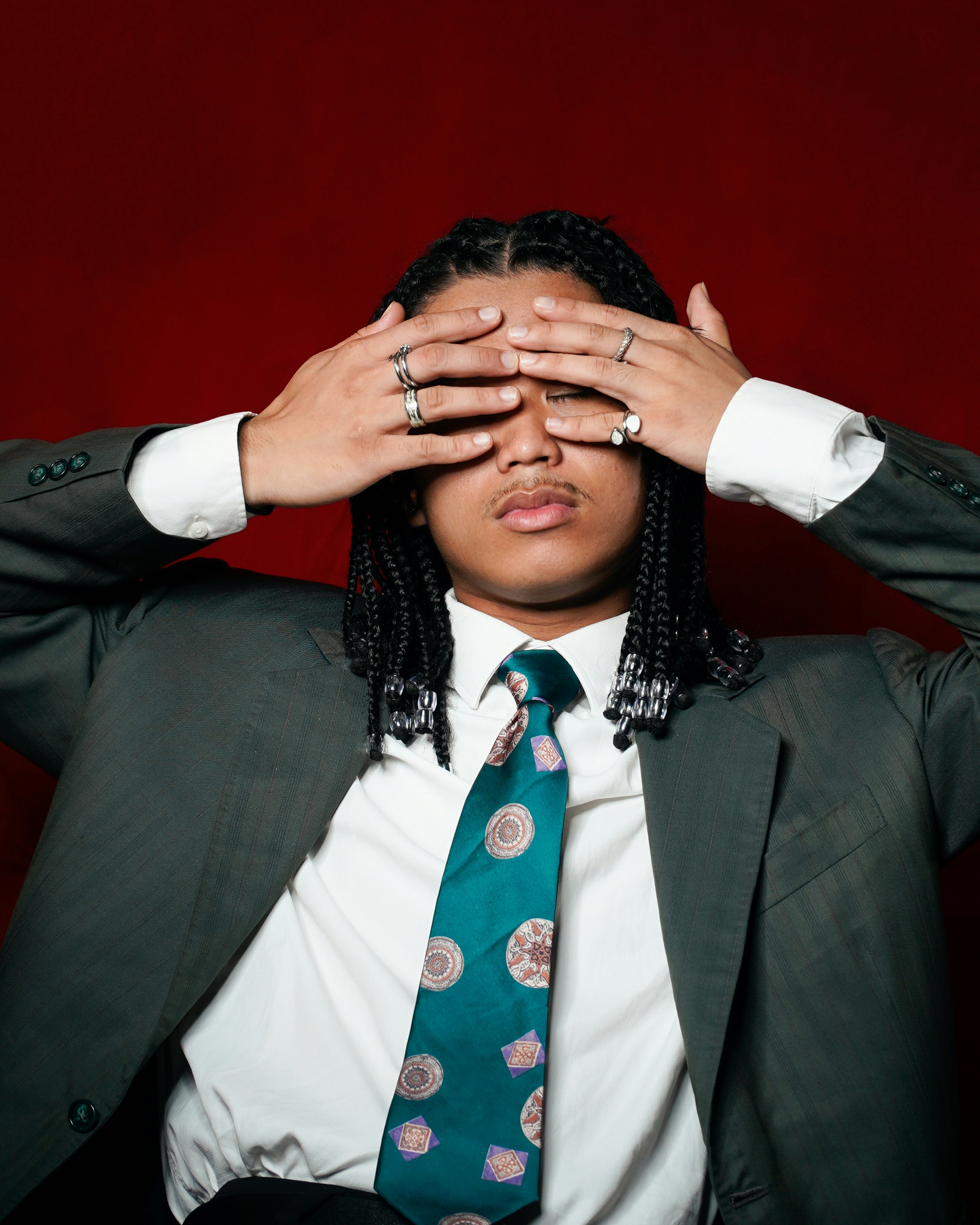 Young man in suit covers eyes with hands