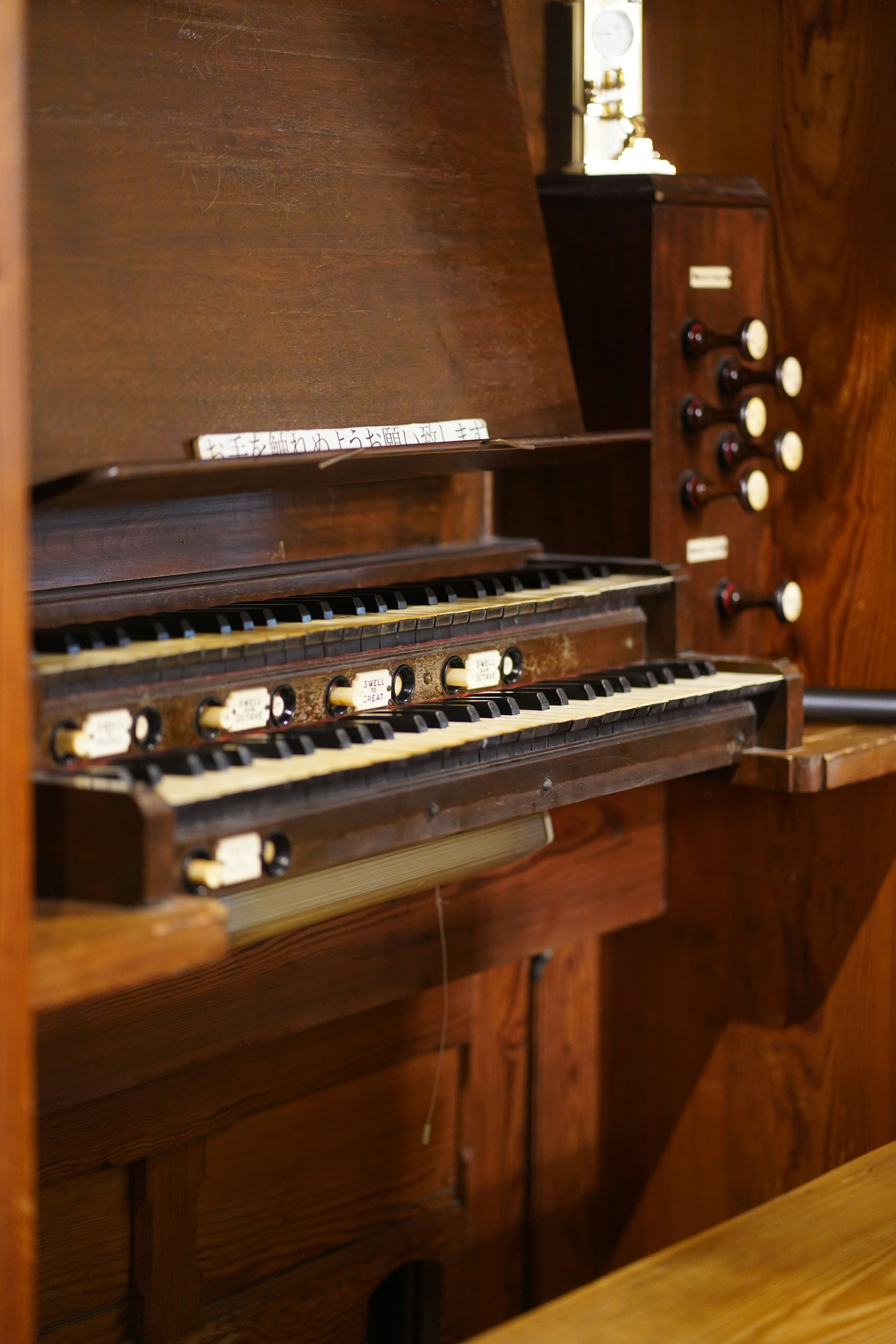 Close-up of a wooden pipe organ keyboard and keyboards.