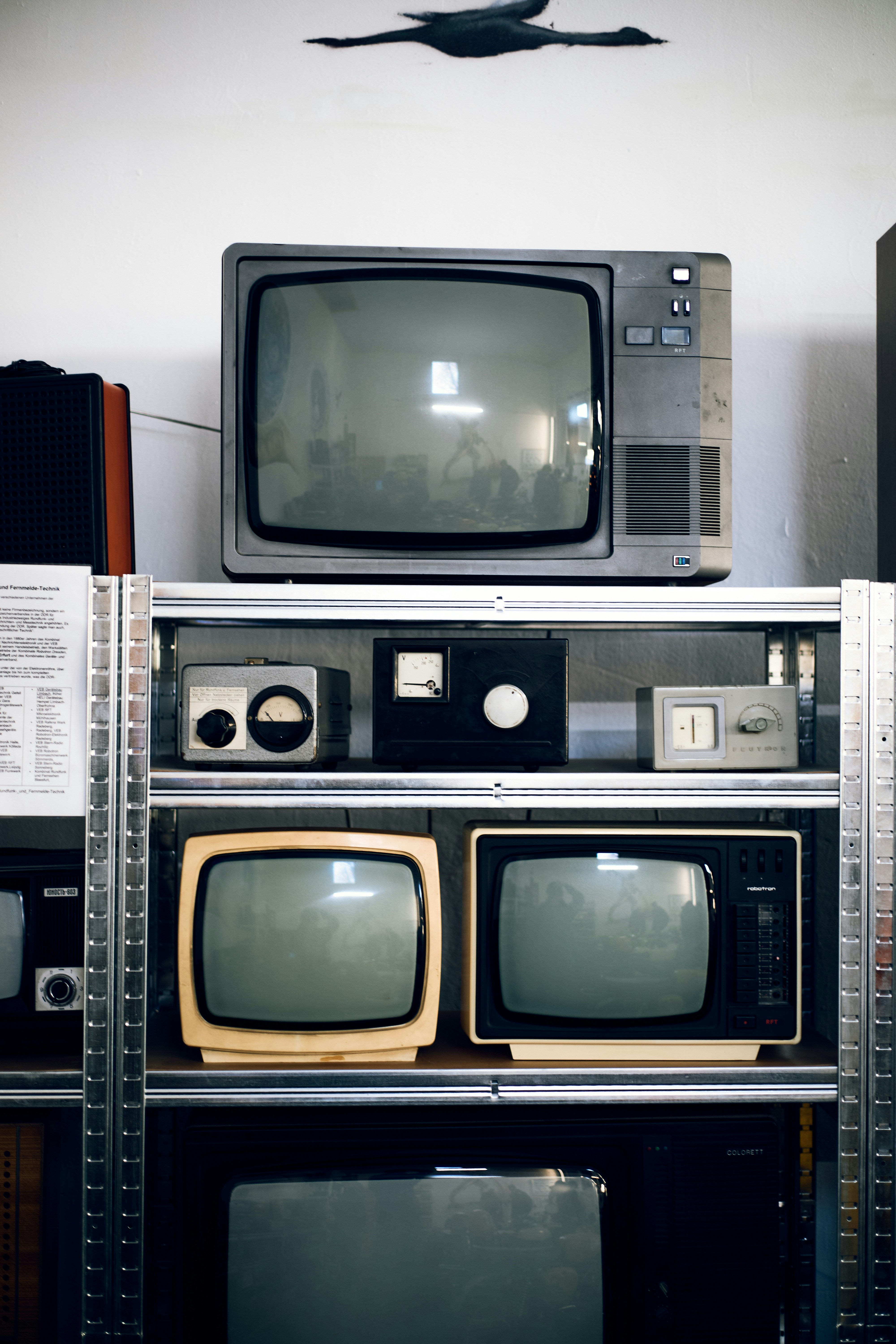 Vintage televisions and radios displayed on shelves