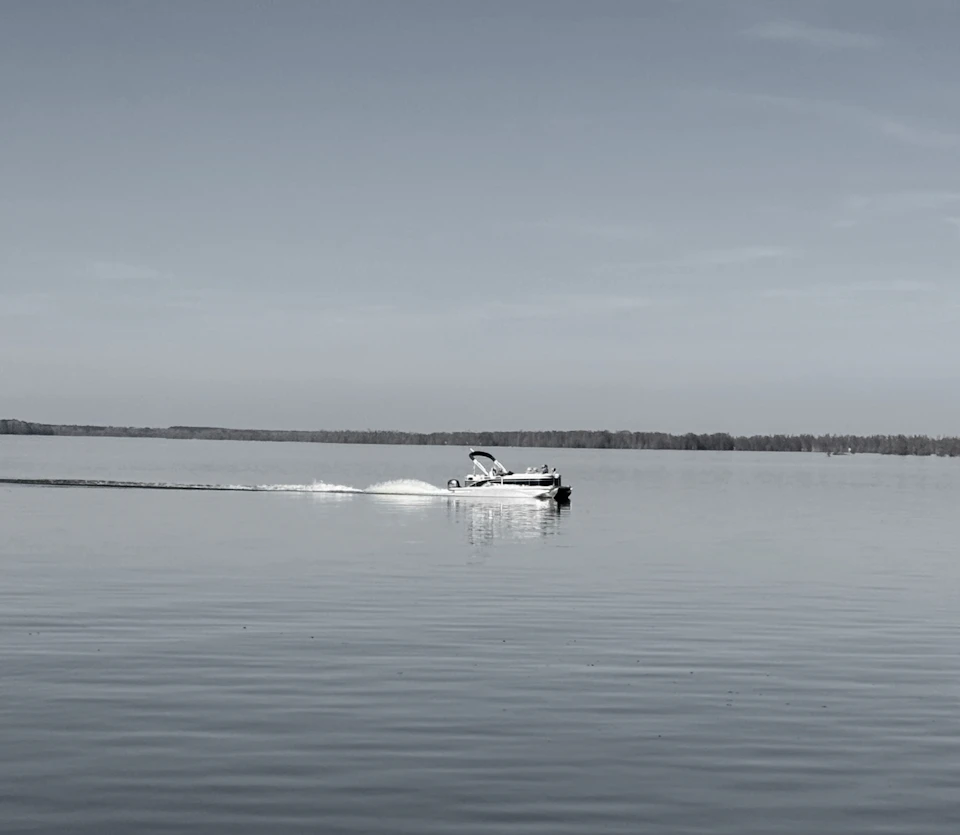 Boat traveling across a calm lake