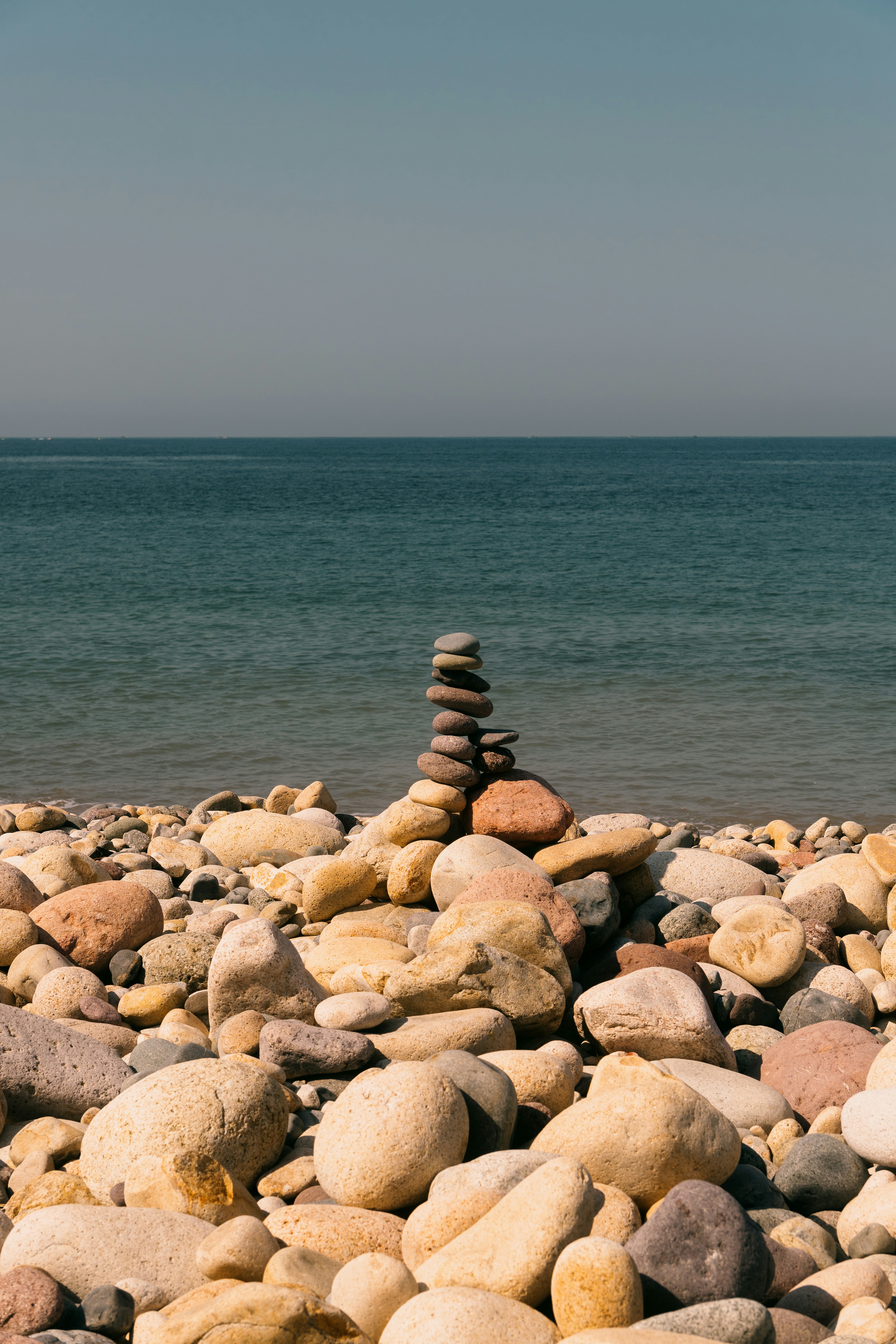 Stacked stones on a rocky beach overlooking the ocean