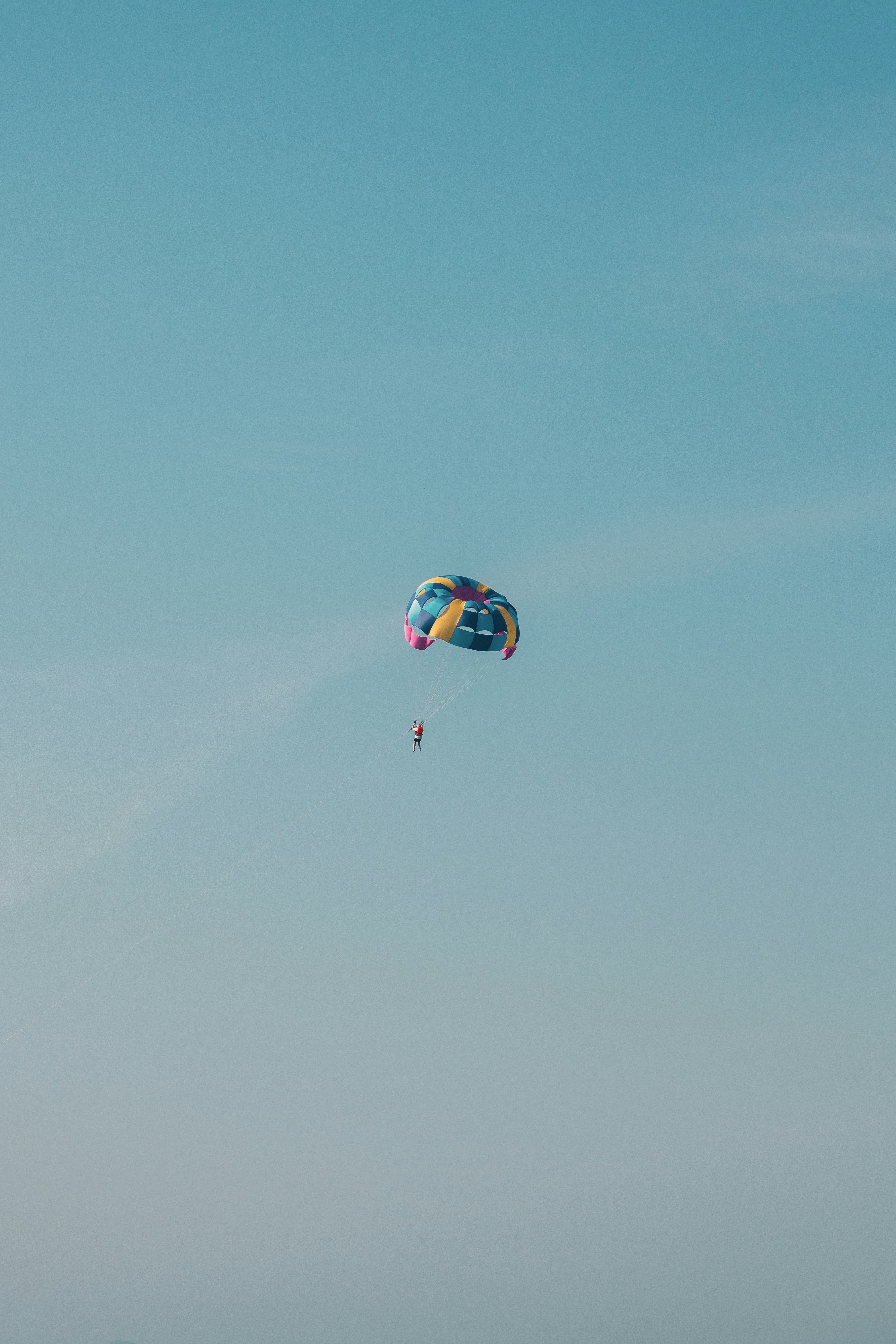 Parachutiste planant à travers un ciel bleu clair
