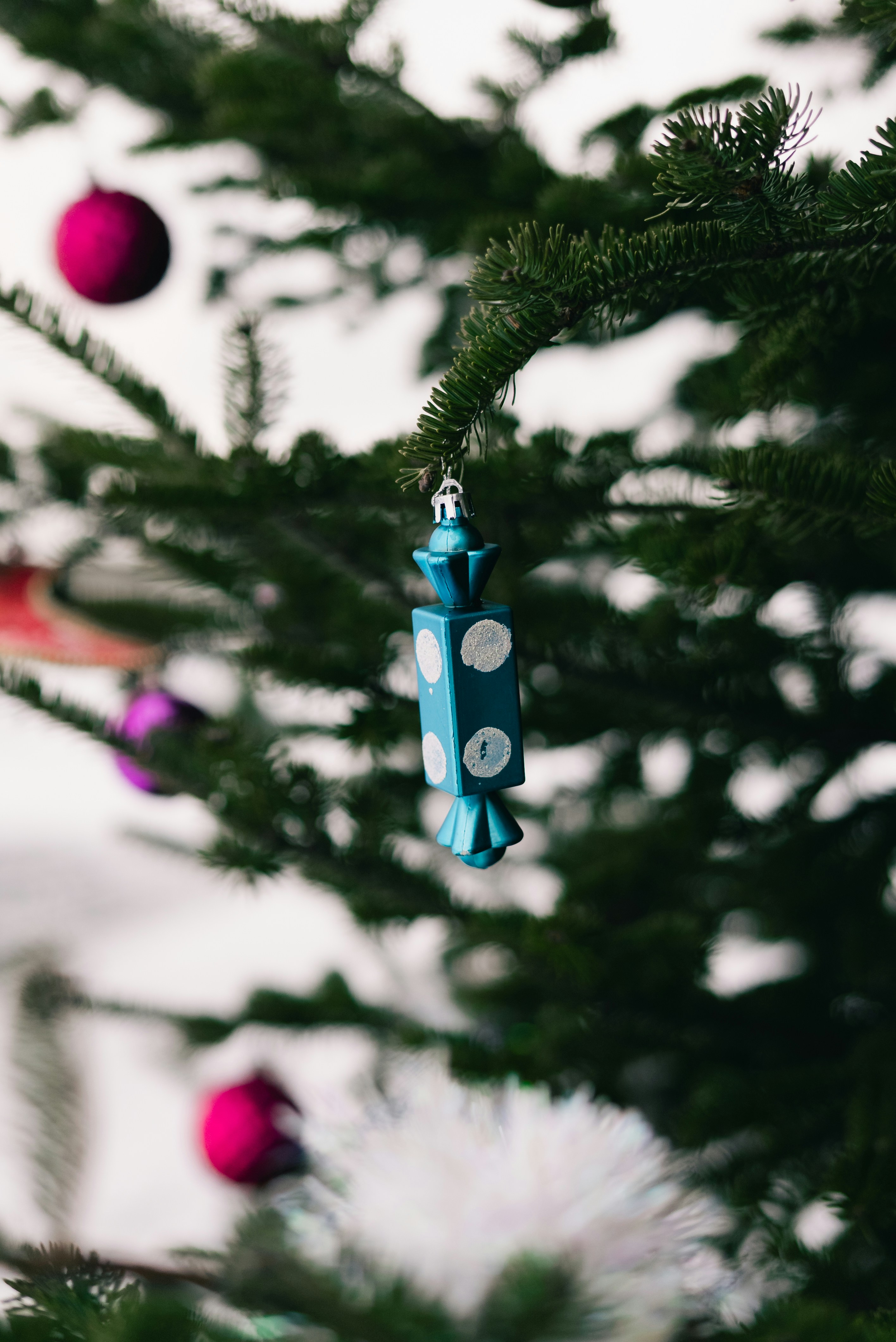 Close-up of a blue candy ornament on a christmas tree.