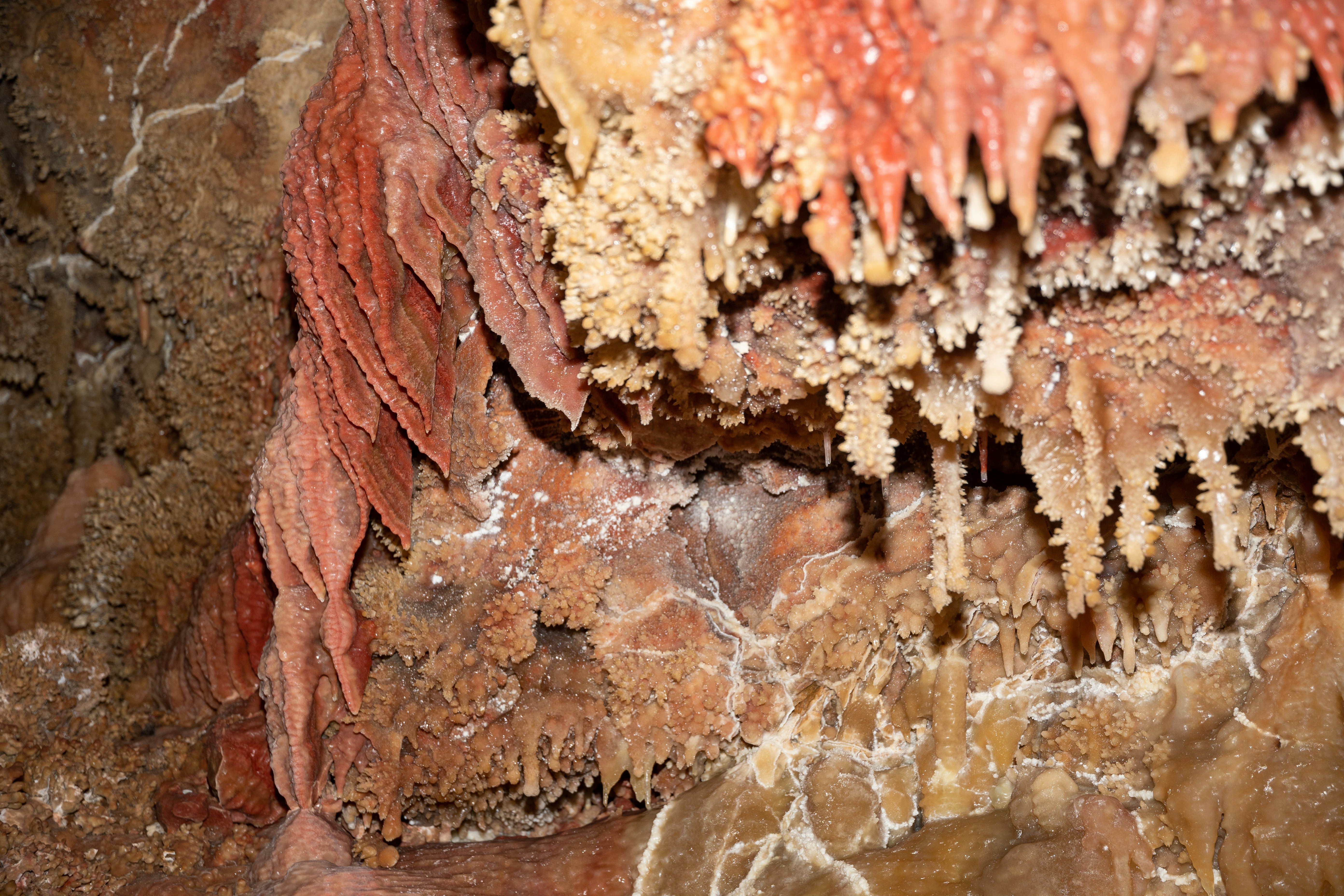 Close-up of colorful stalactites and stalagmites in a cave.