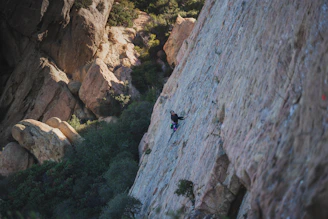 A lone climber scales a sheer rock face.