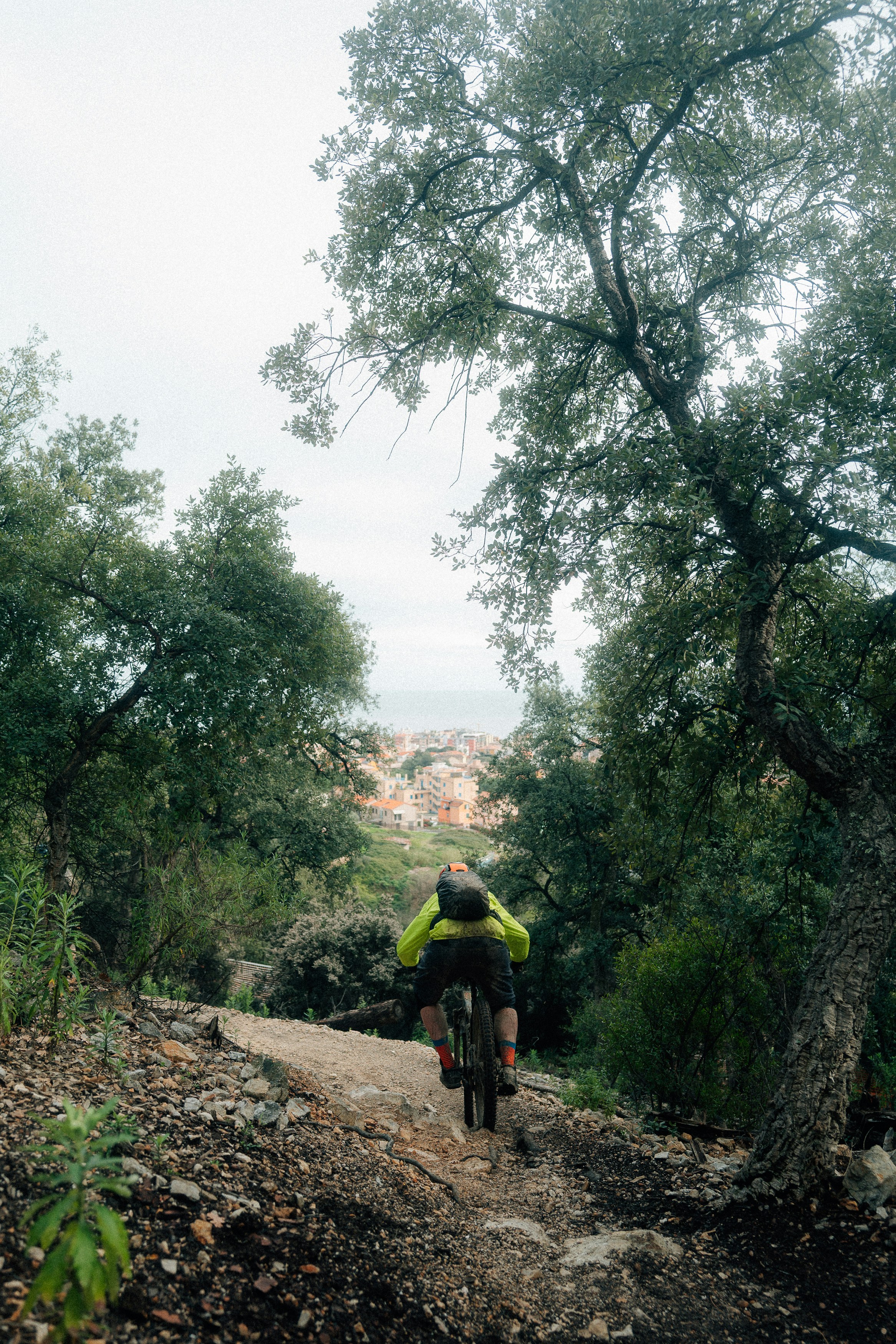 Mountain biker descends a rocky trail towards town.