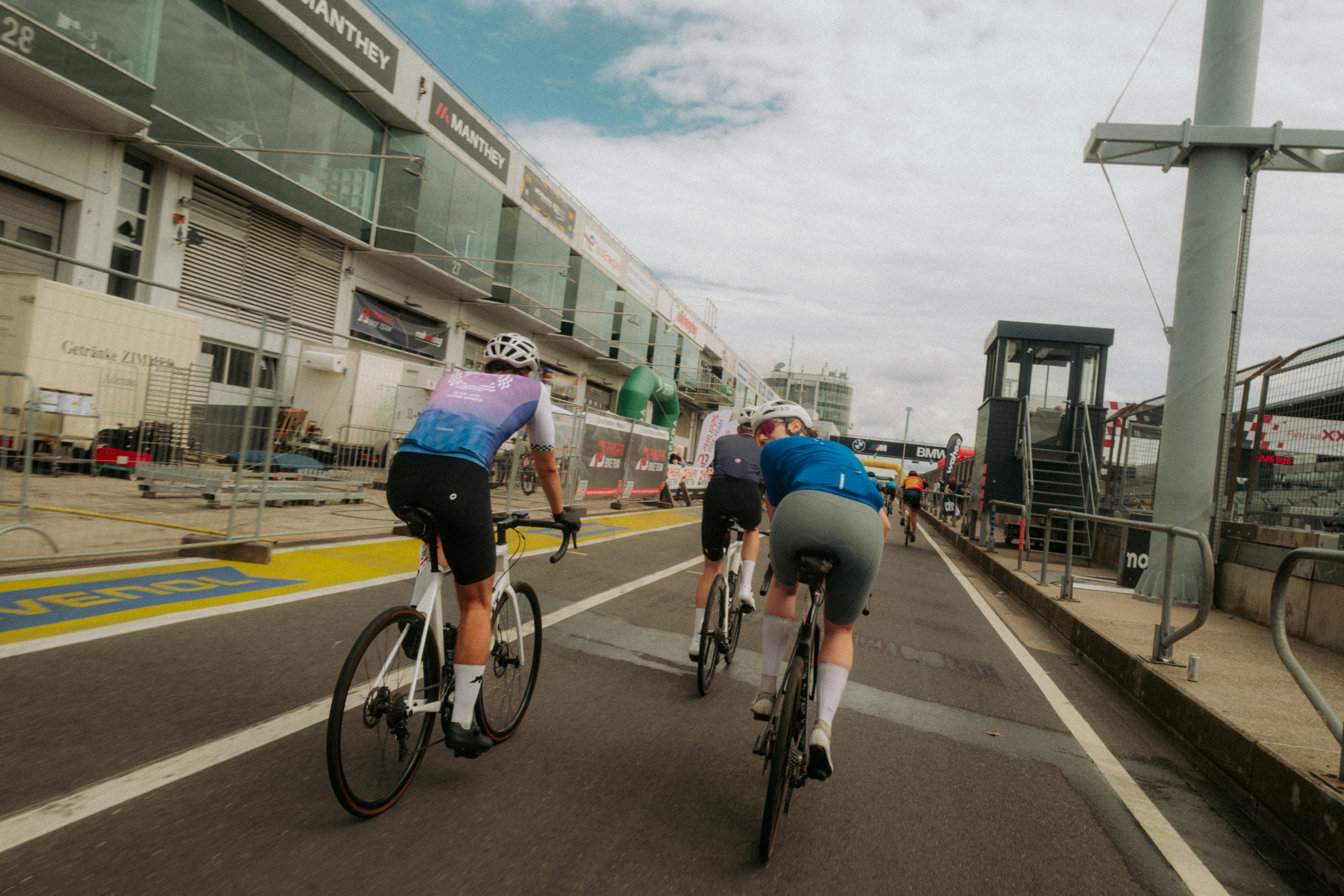 Cyclists riding on a paved track near buildings
