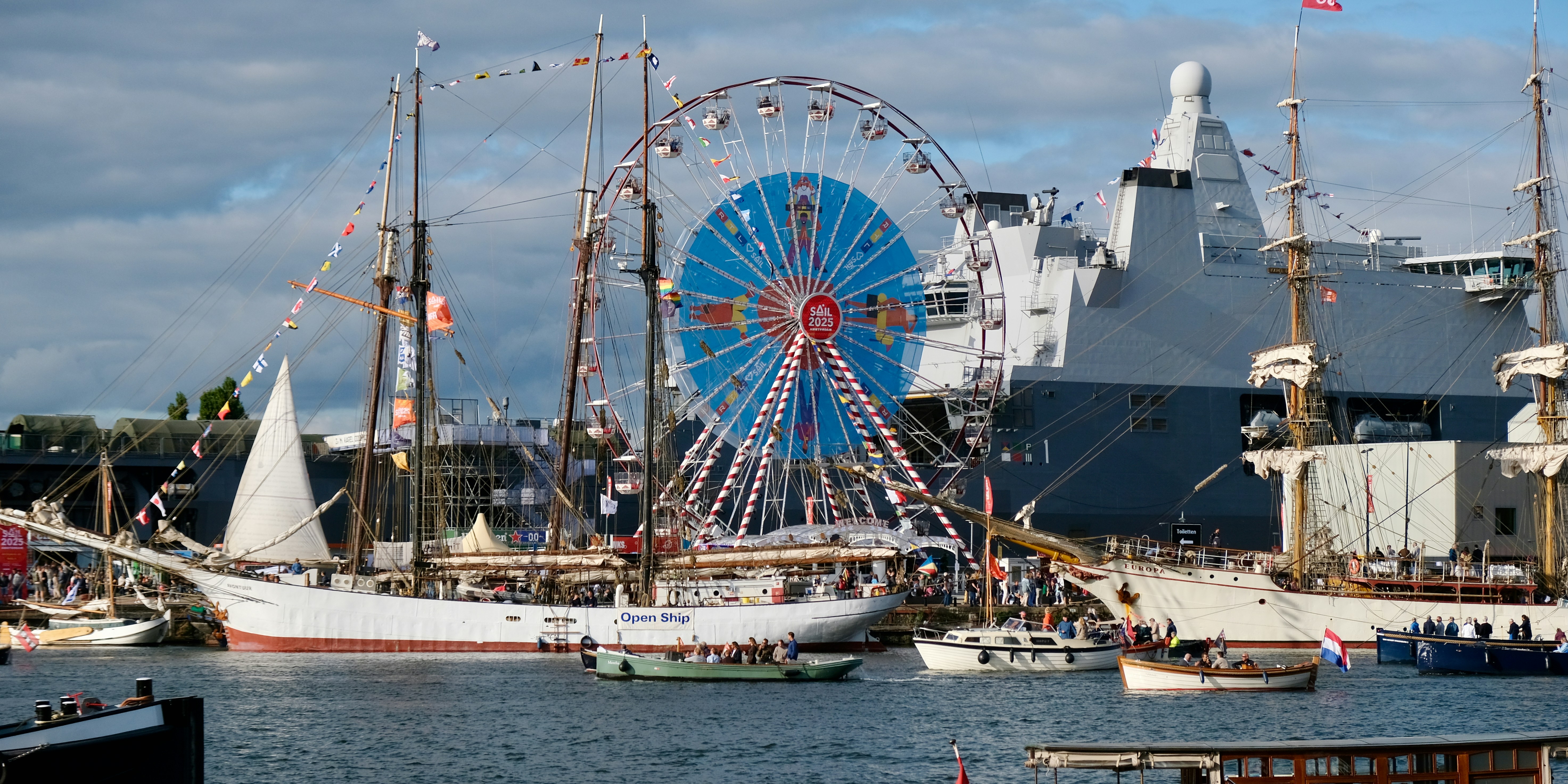 Tall ships and ferris wheel at a harbor festival