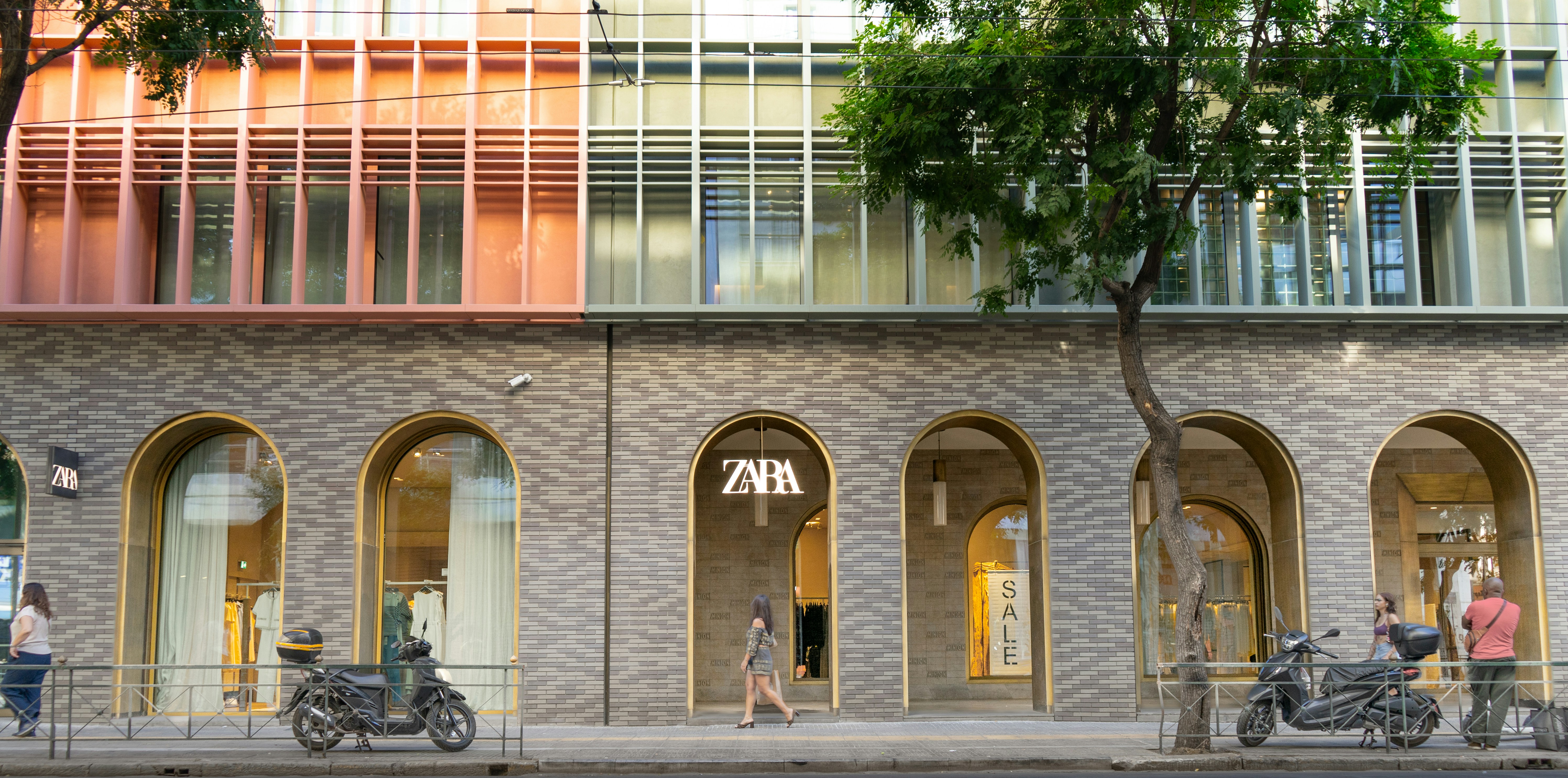Modern building facade with arched storefronts and windows.