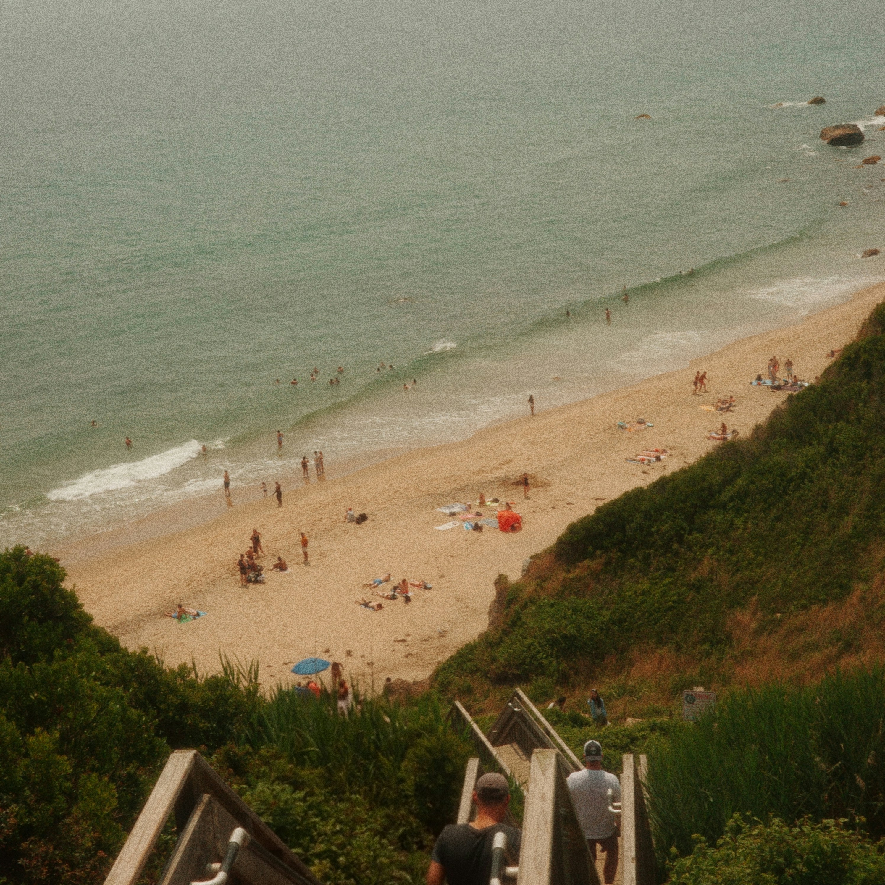 People enjoying a sandy beach with ocean waves.