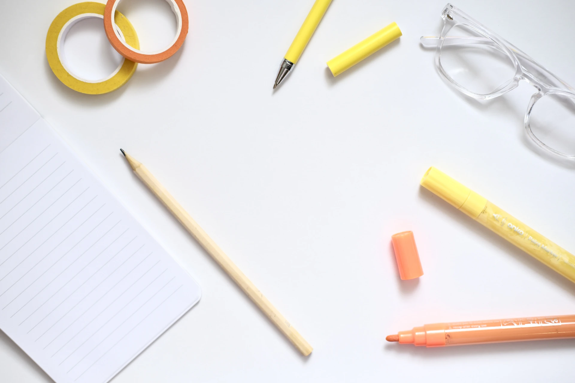 Desk supplies including pens, markers, and glasses