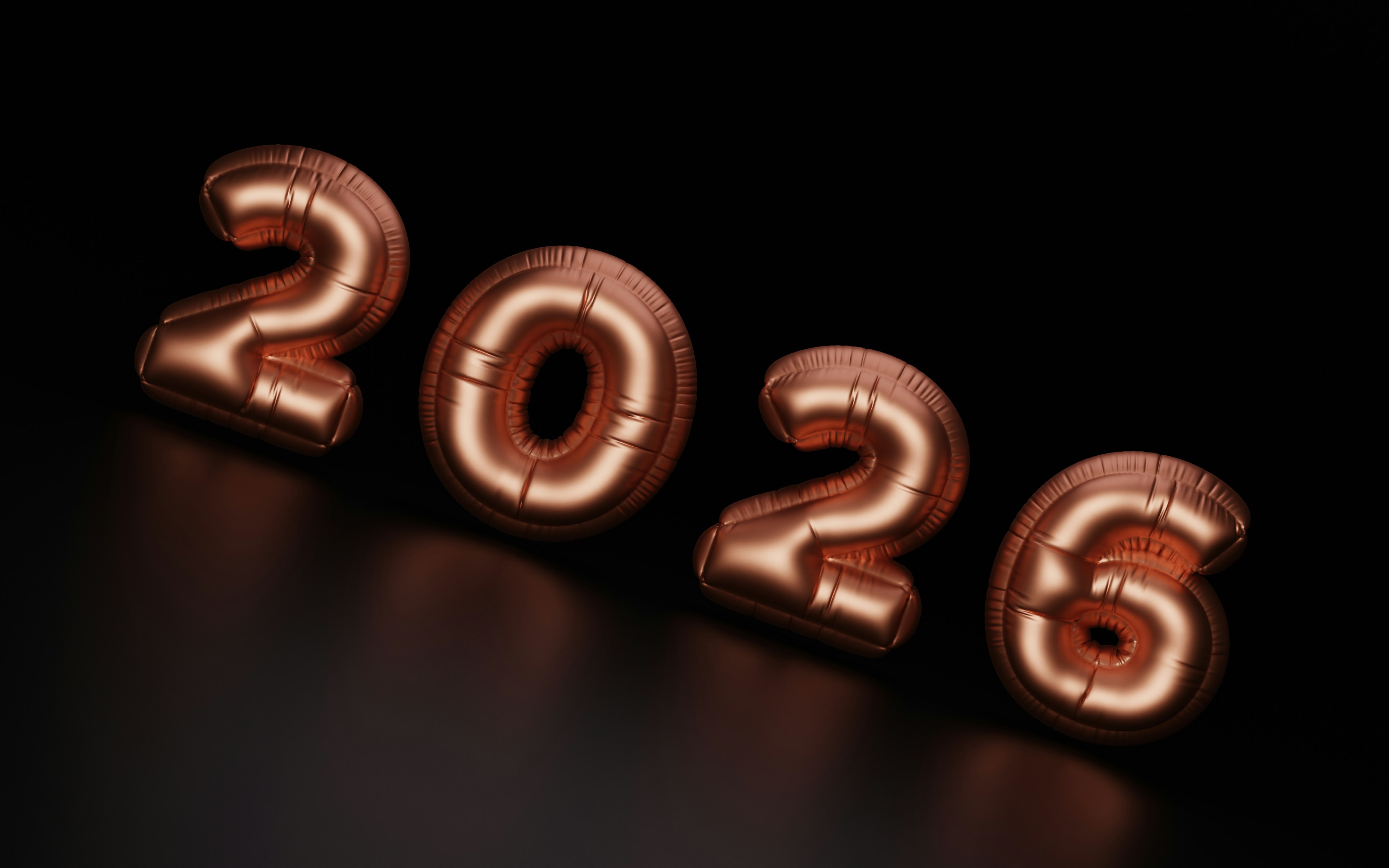 Rose gold balloons spell out 2026 on black background