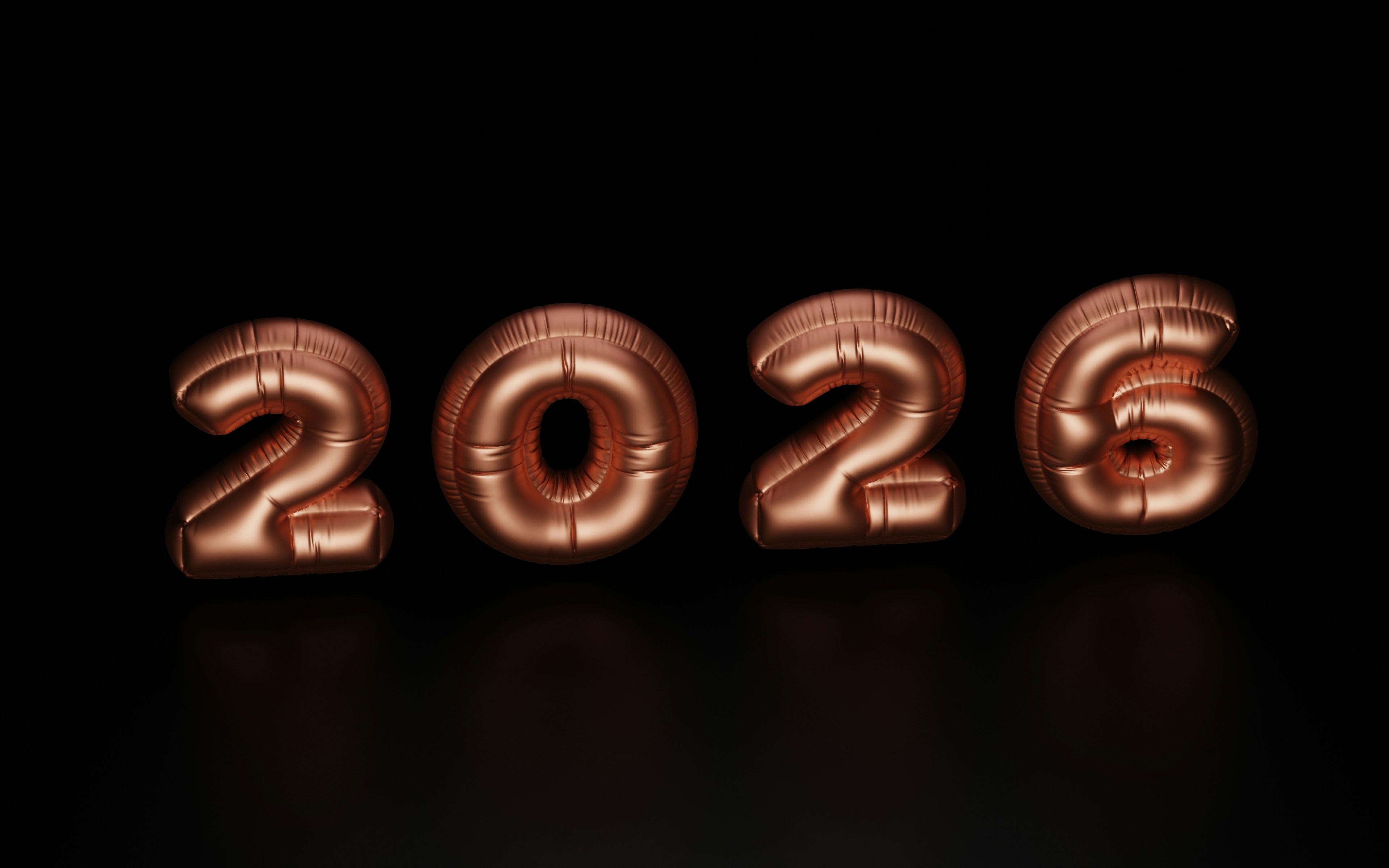 Rose gold balloons spell out 2026 on black background