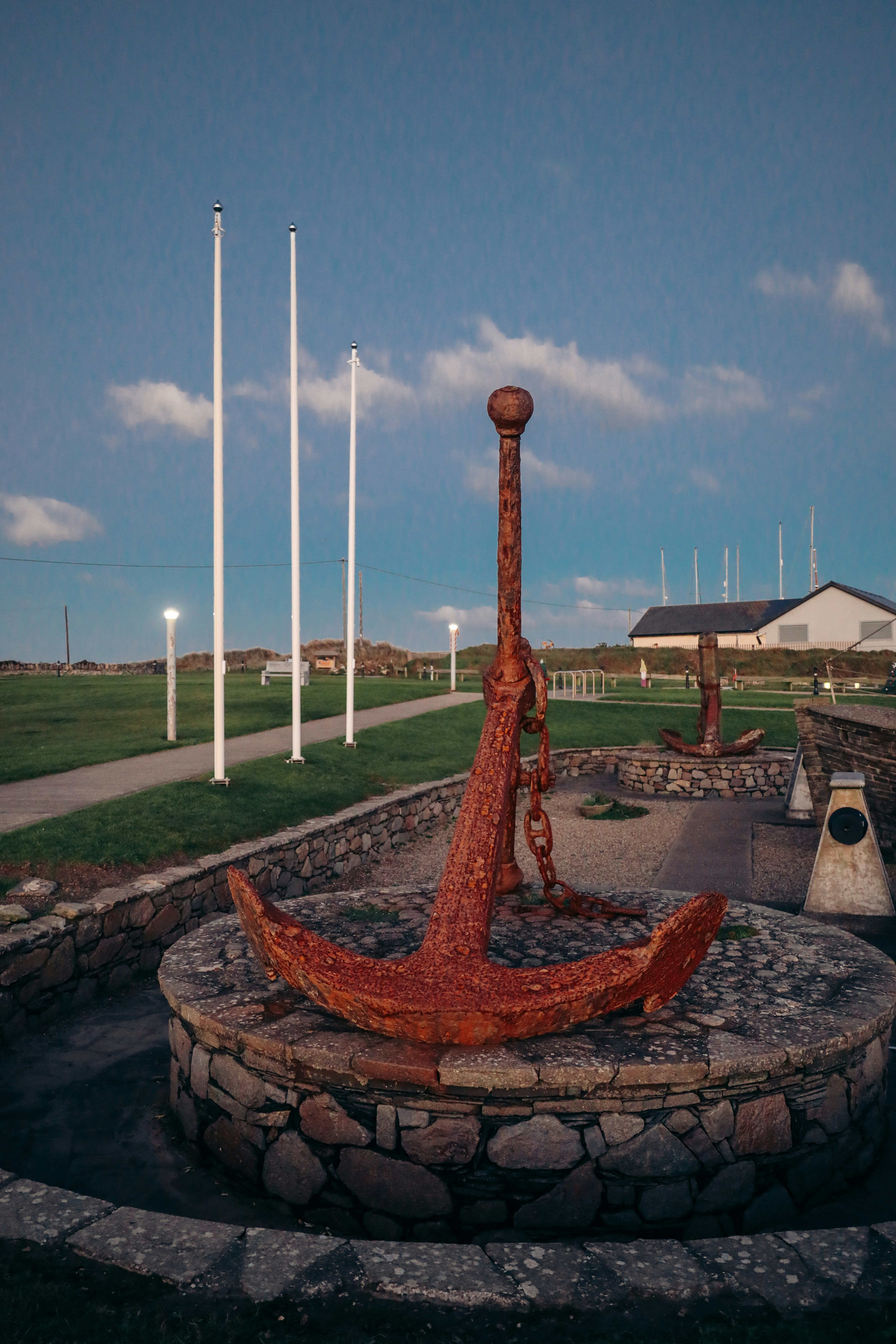 Rostiger Anker auf einem steinernen Sockel im Außenbereich ausgestellt