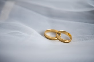 Two gold wedding rings on white fabric