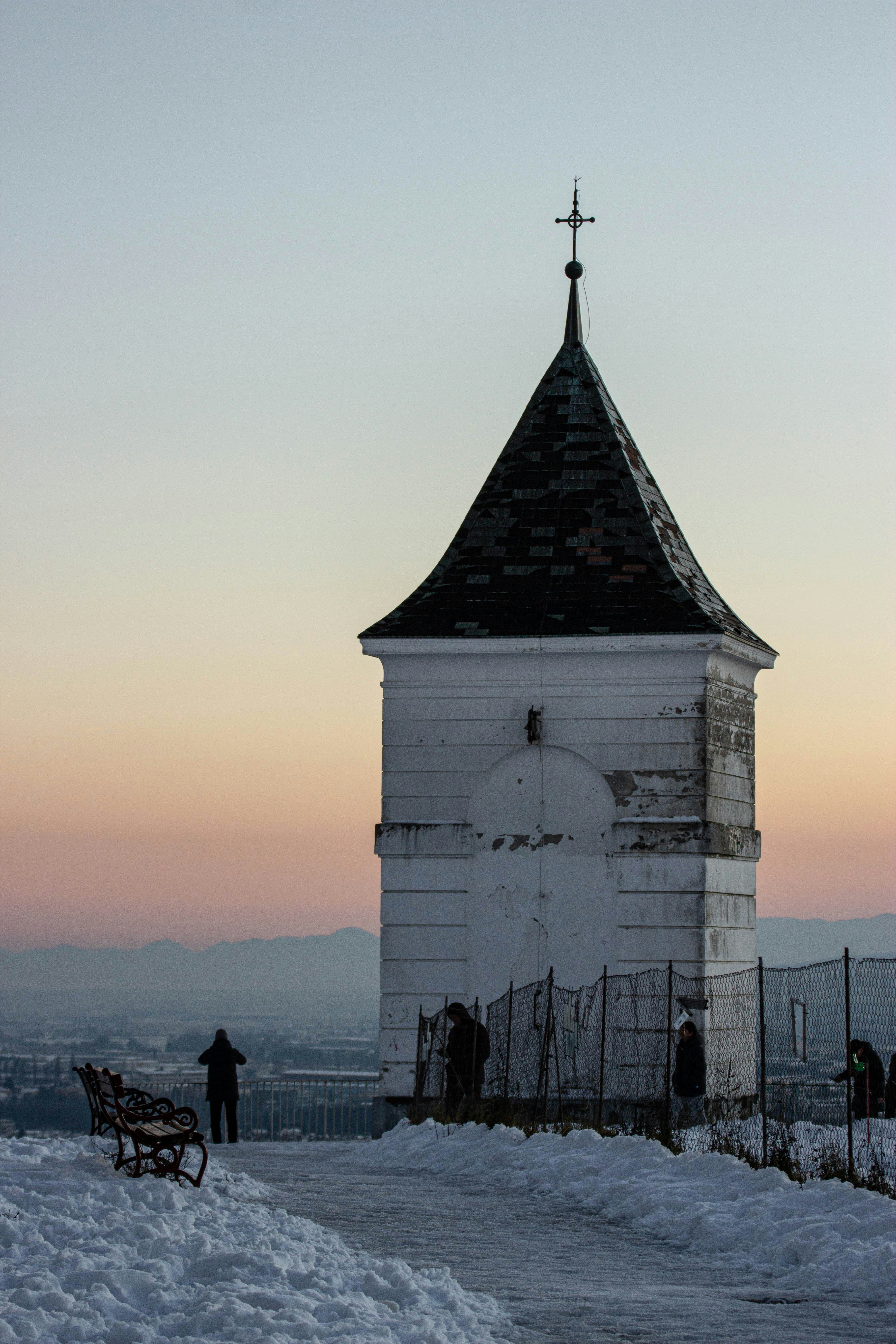 Chapel with people and snow at sunset