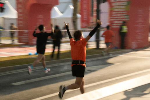 Runner celebrating crossing the finish line at a marathon.