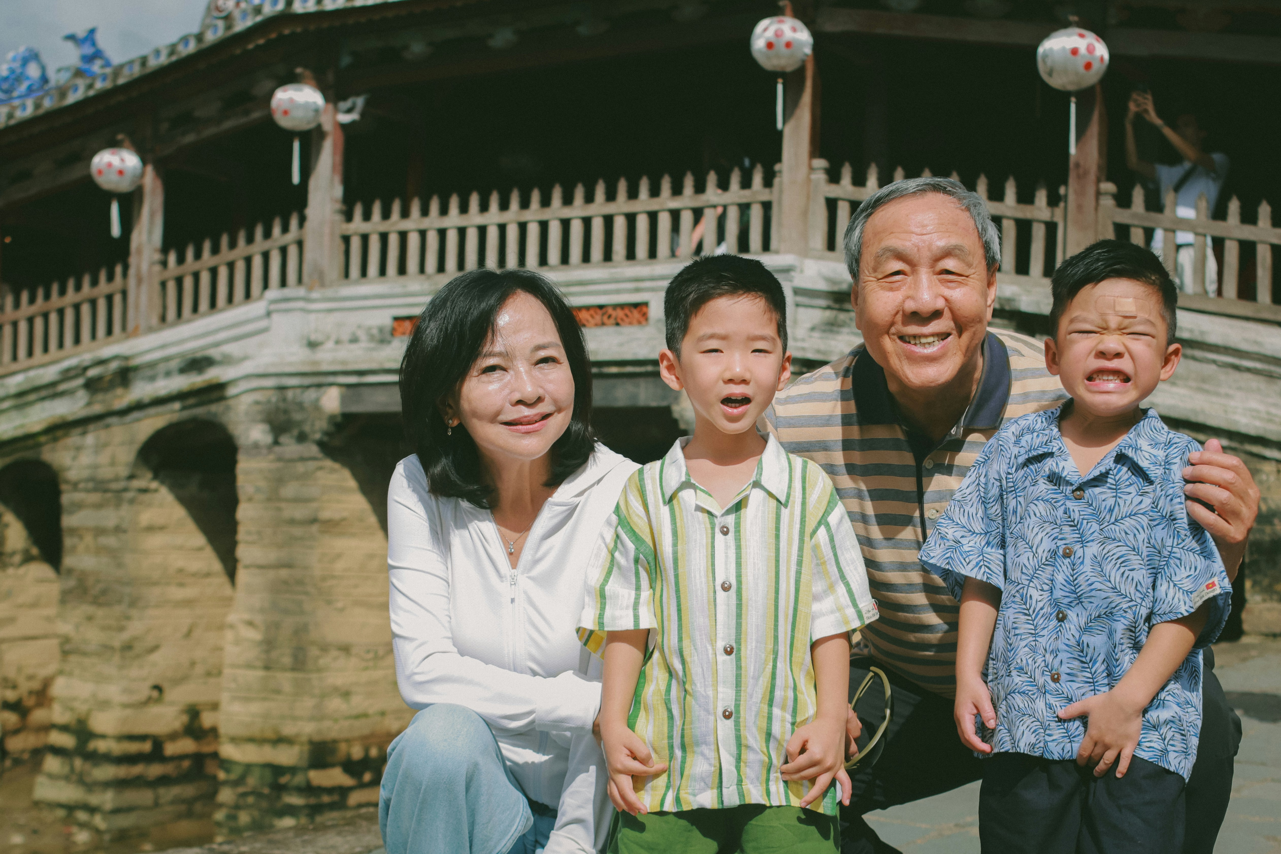 Una famiglia posa davanti a un ponte.