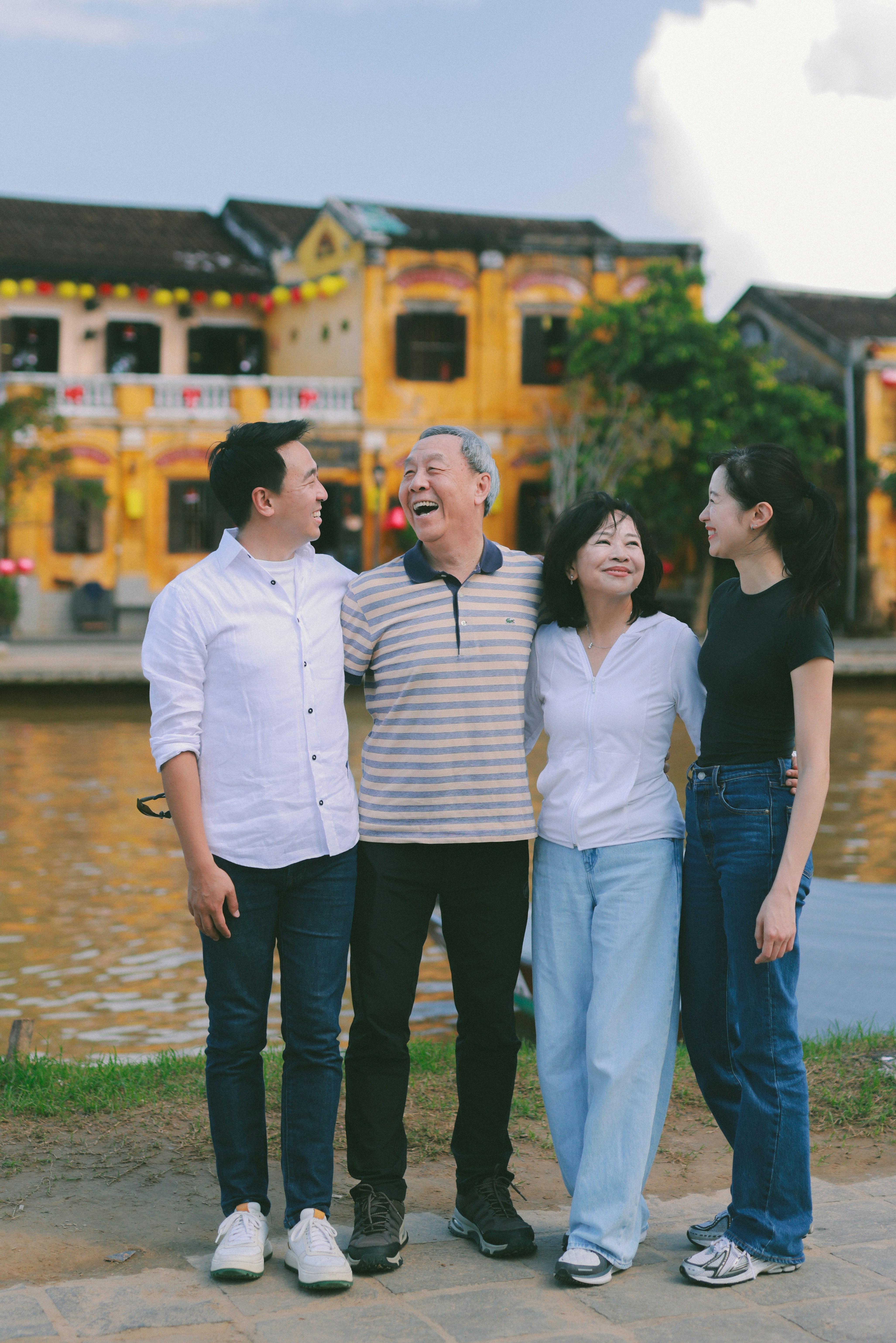 Eine mehrgenerationenübergreifende Familie lächelt gemeinsam draußen.