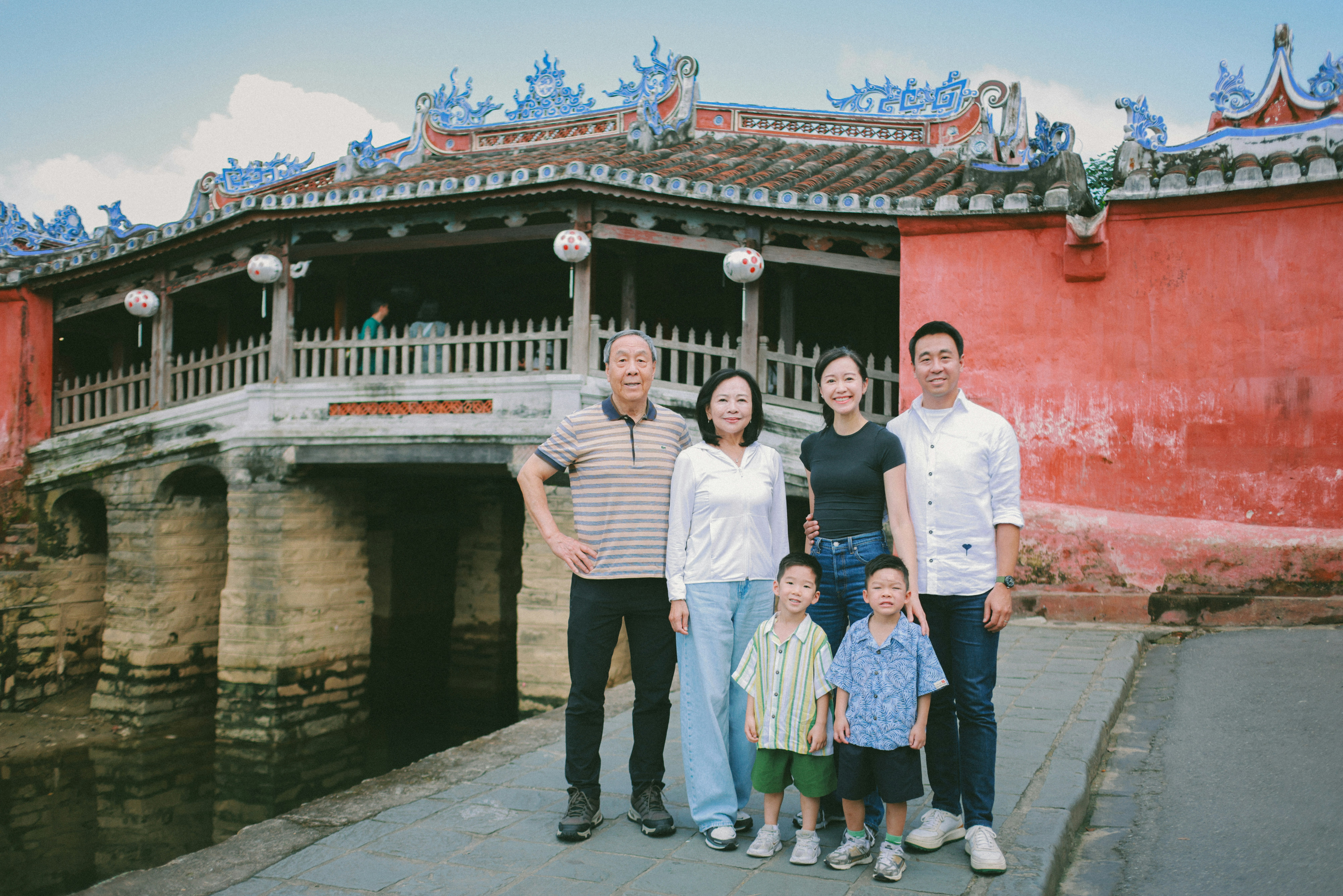 Familie posiert vor einer historischen japanischen Brücke.