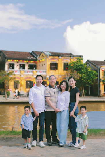 A multi-generational family poses outdoors with buildings behind them