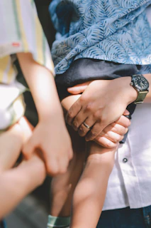 Adults holding a child's hands and another person's hands