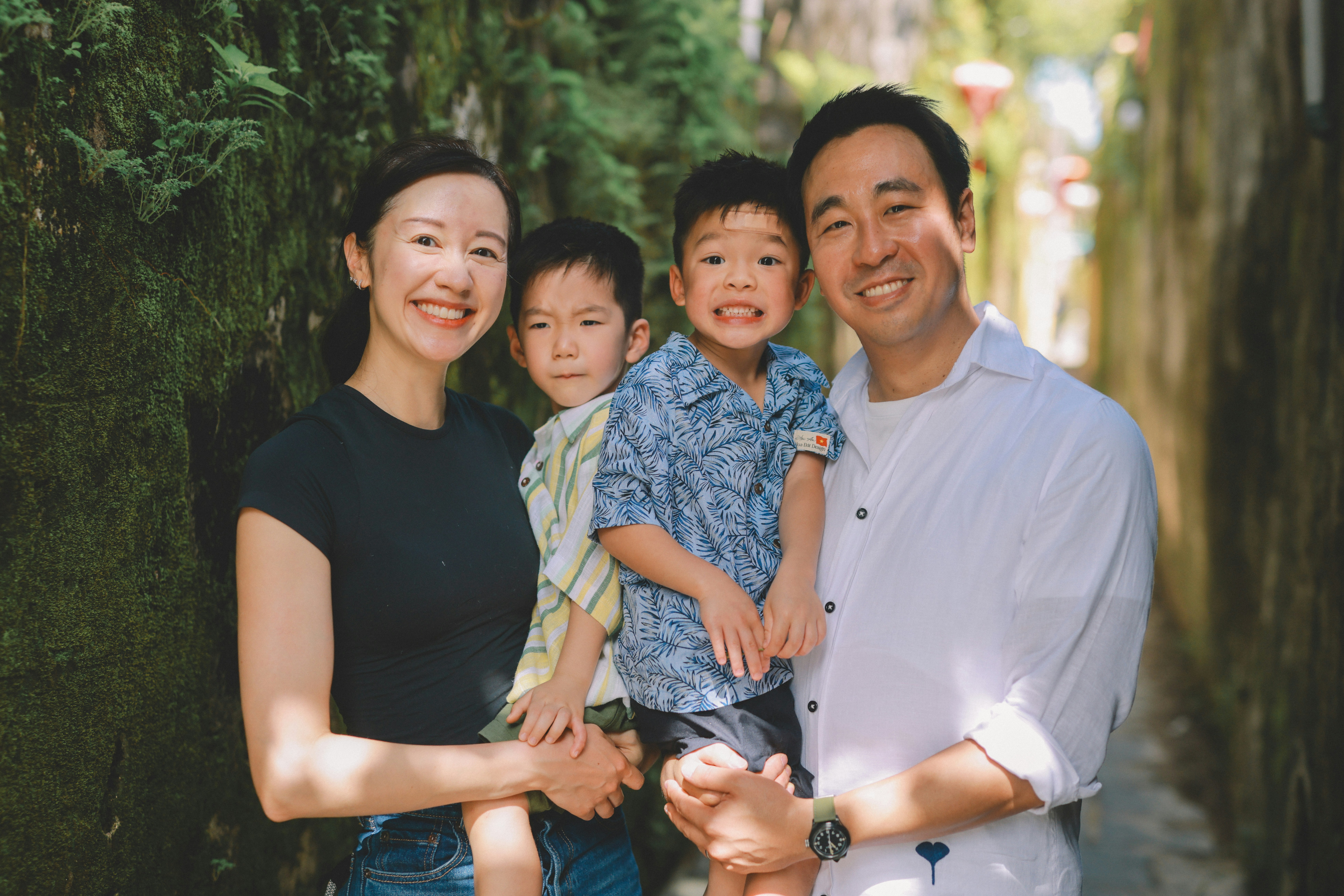 A happy family of four posing outdoors
