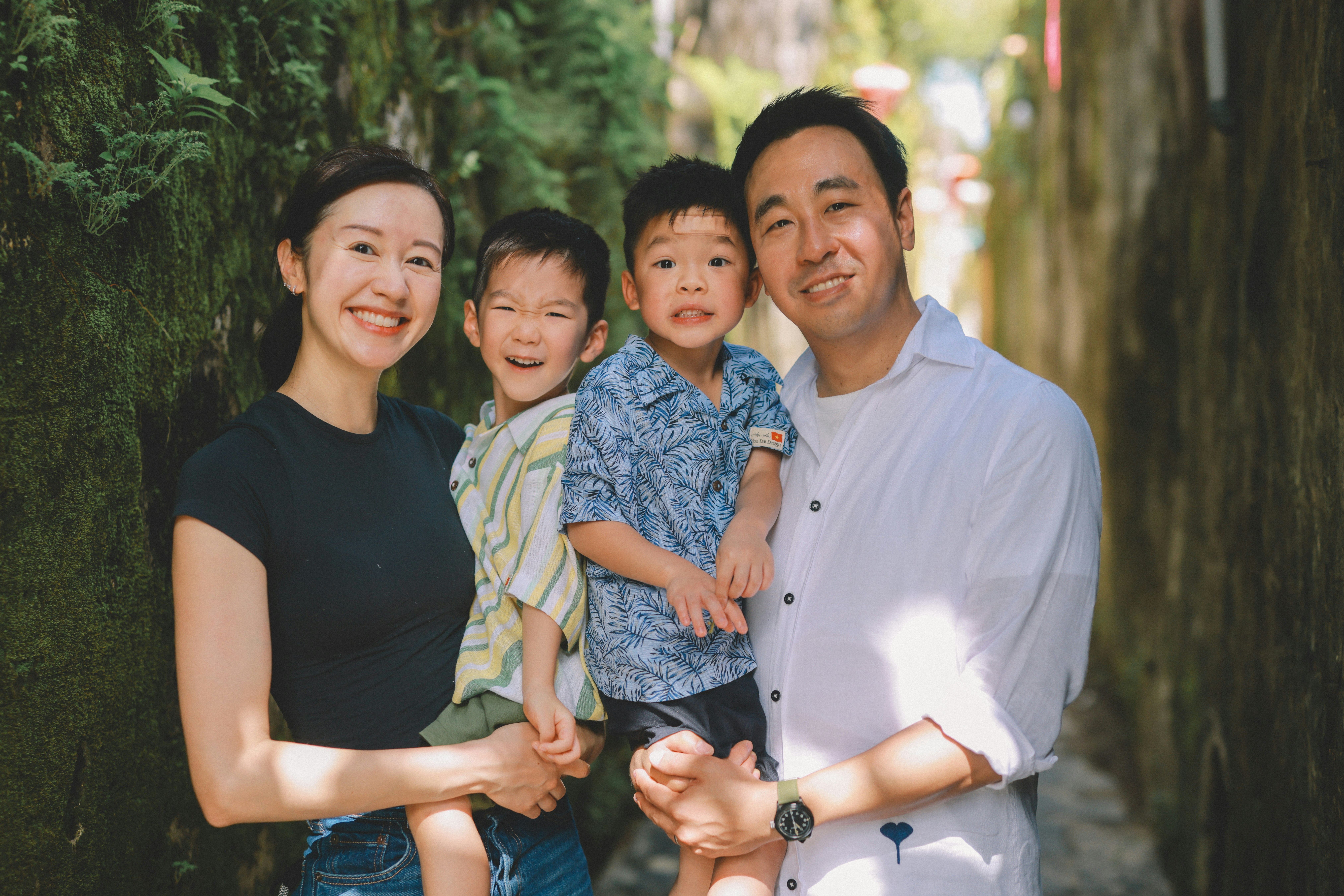 A smiling family of four posing outdoors