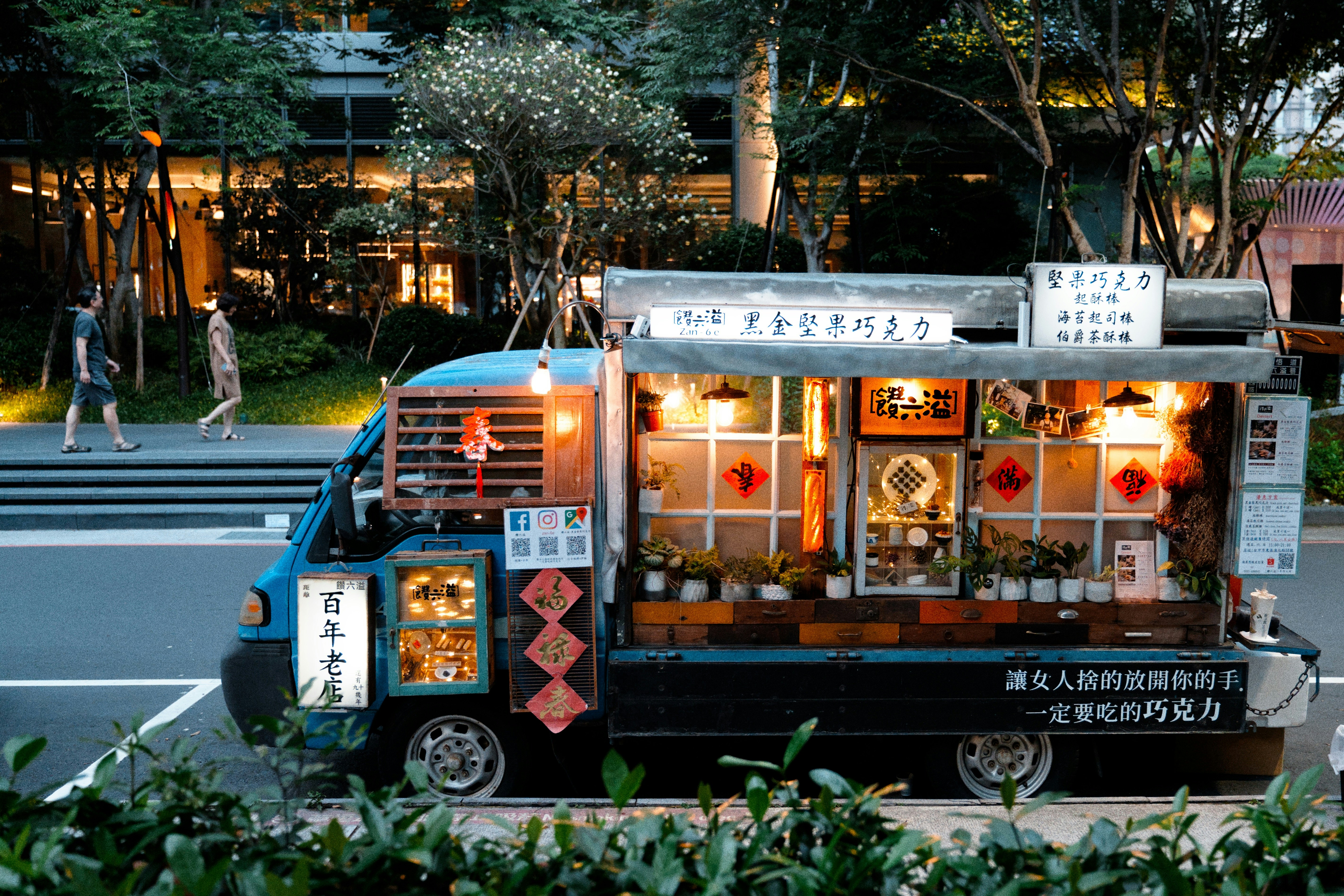 A food truck with lights and decorations at night.
