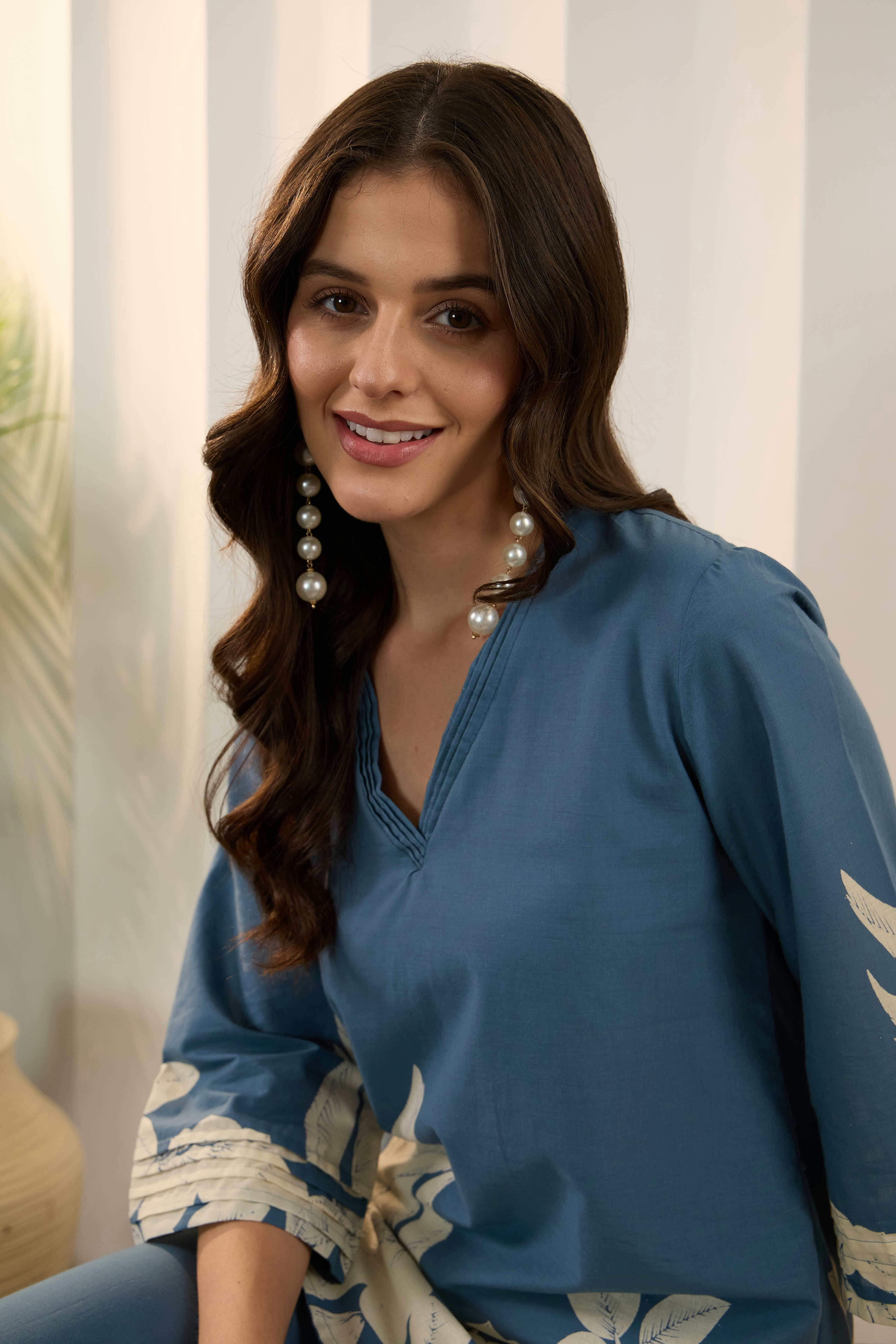 A woman with long dark hair wearing blue