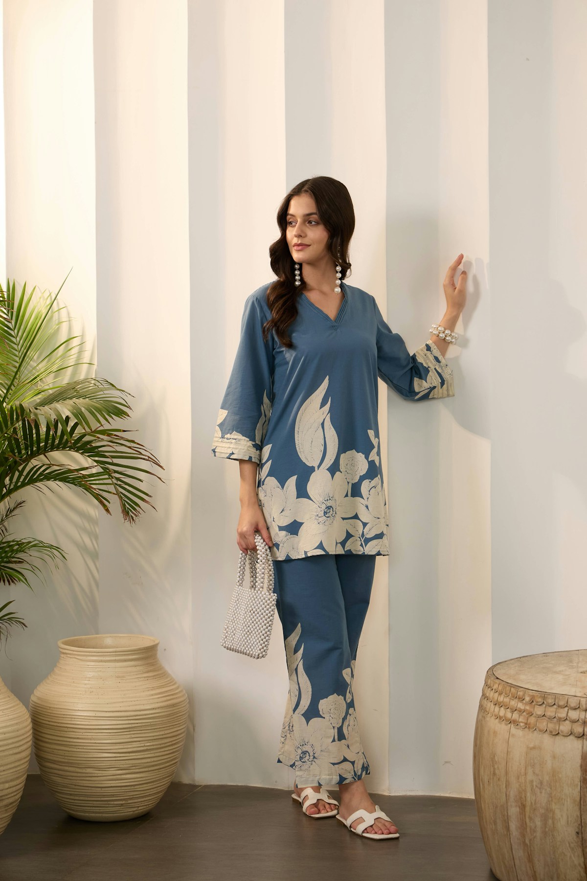woman-in-blue-floral-outfit-holding-a-small-bag-AcVHftMDk8M collection background image
