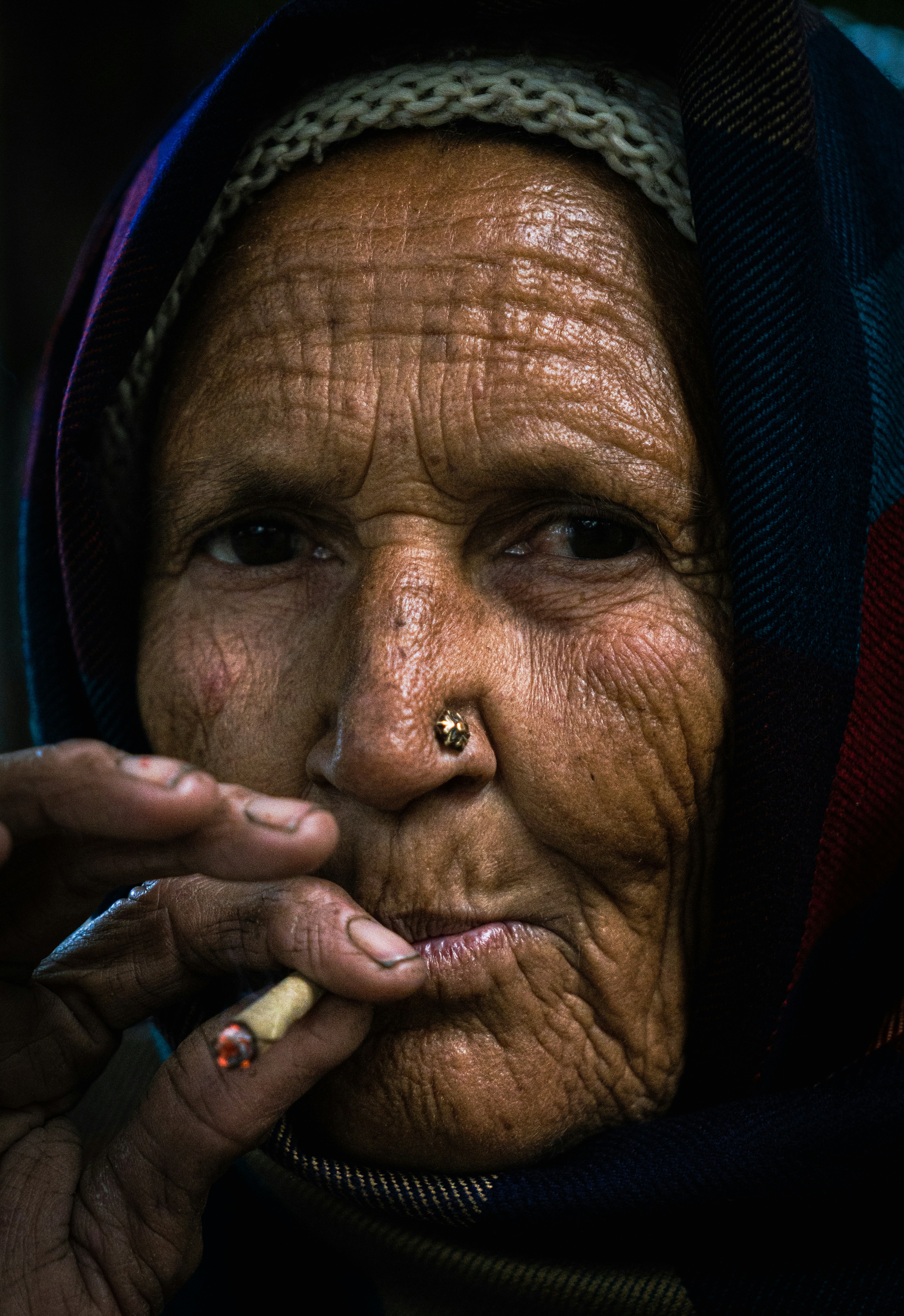 Elderly woman with a cigarette and headscarf