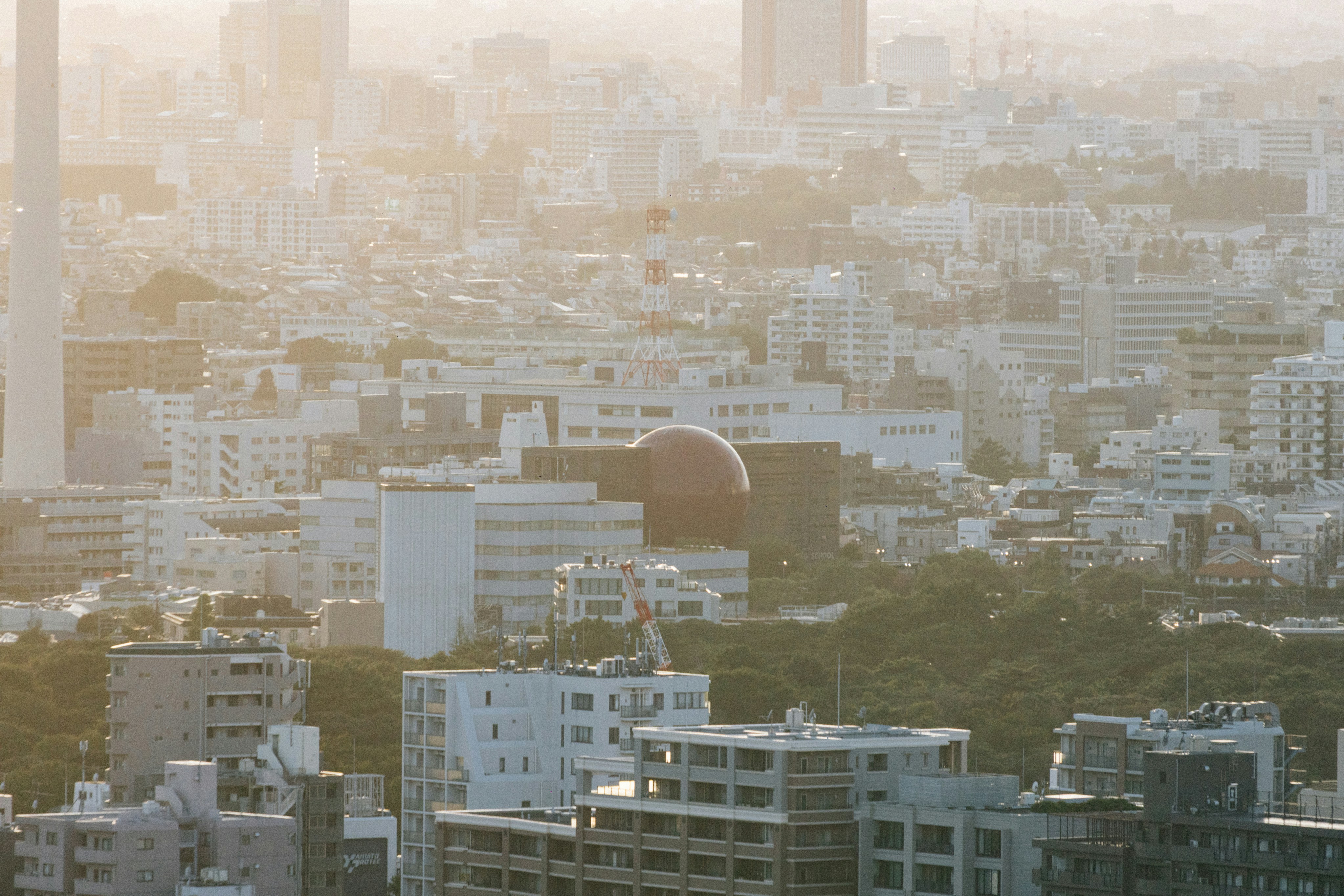 Hazy cityscape with a large red spherical building.
