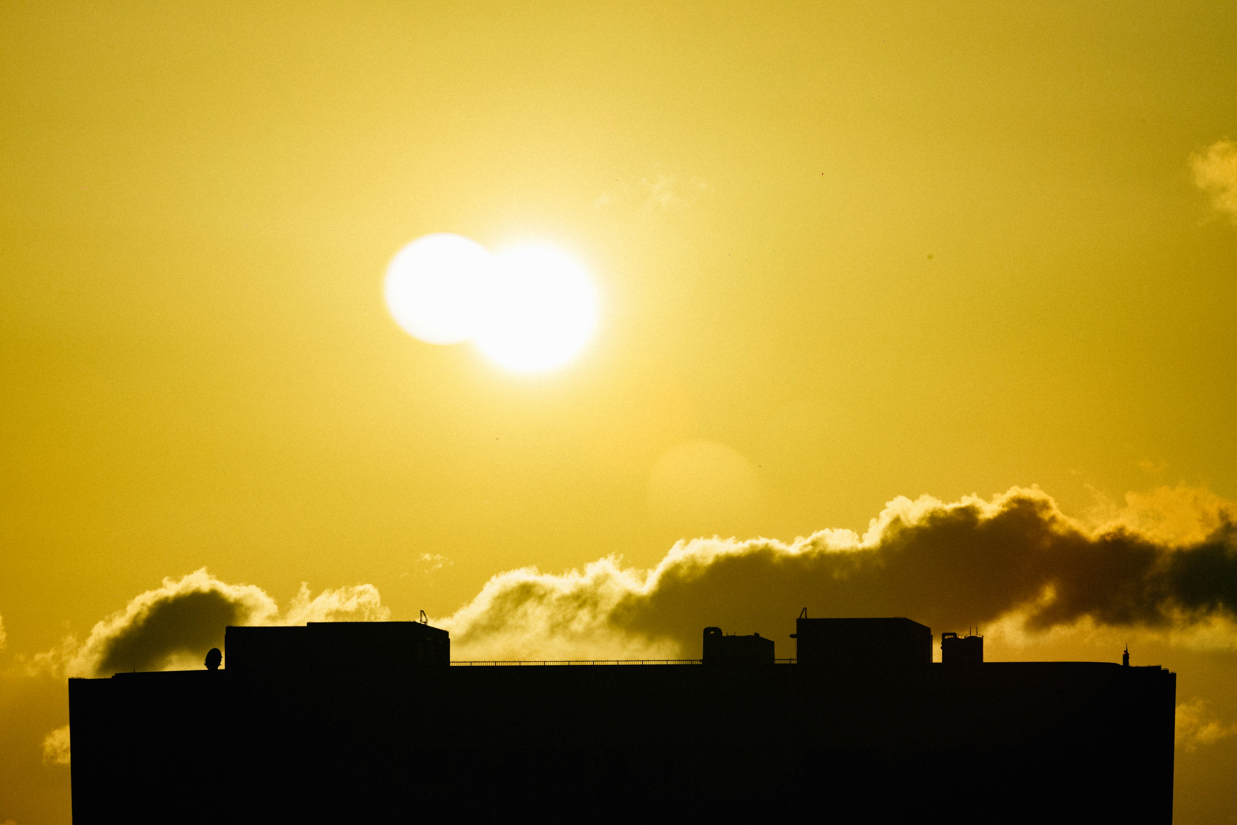明るい黄色の夕焼け空を背景に建物のシルエット。の写真 – Unsplashの建物の無料画像, image size:3000x2000