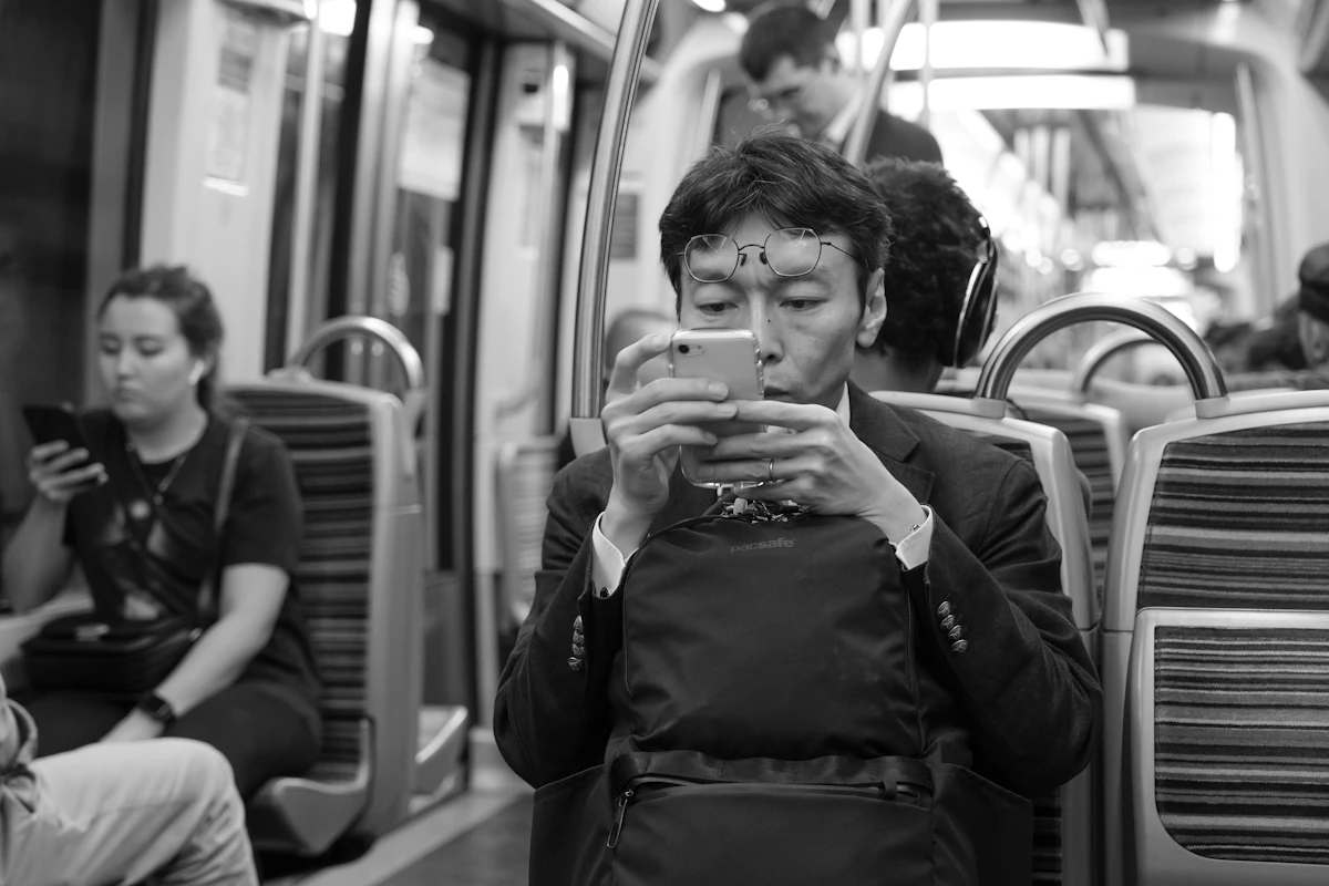 Man using phone on crowded subway train
