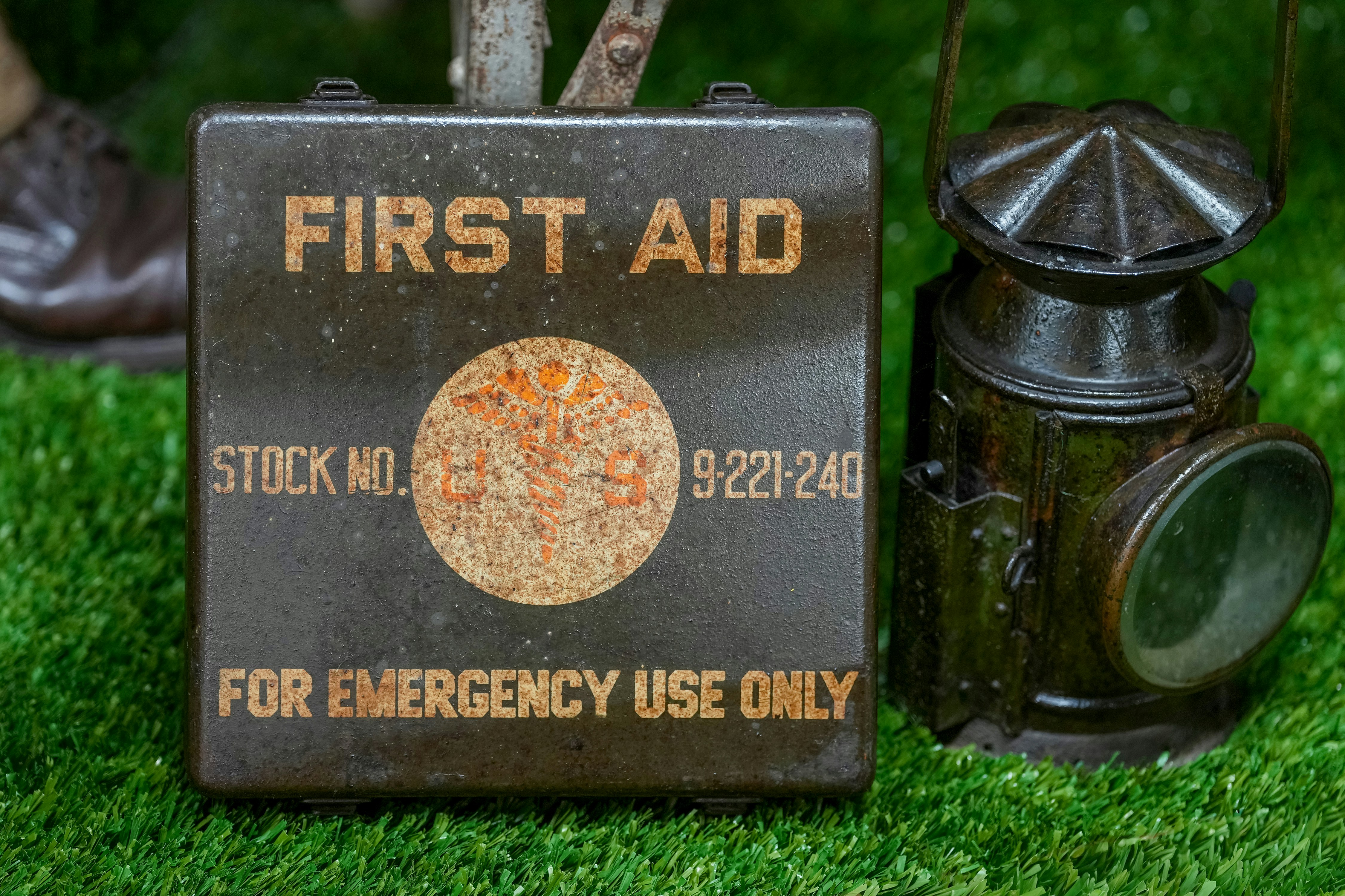 Vintage first aid kit and lantern on grass