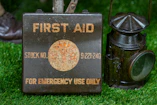 Vintage first aid kit and lantern on grass
