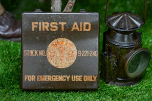 Vintage first aid kit and lantern on grass