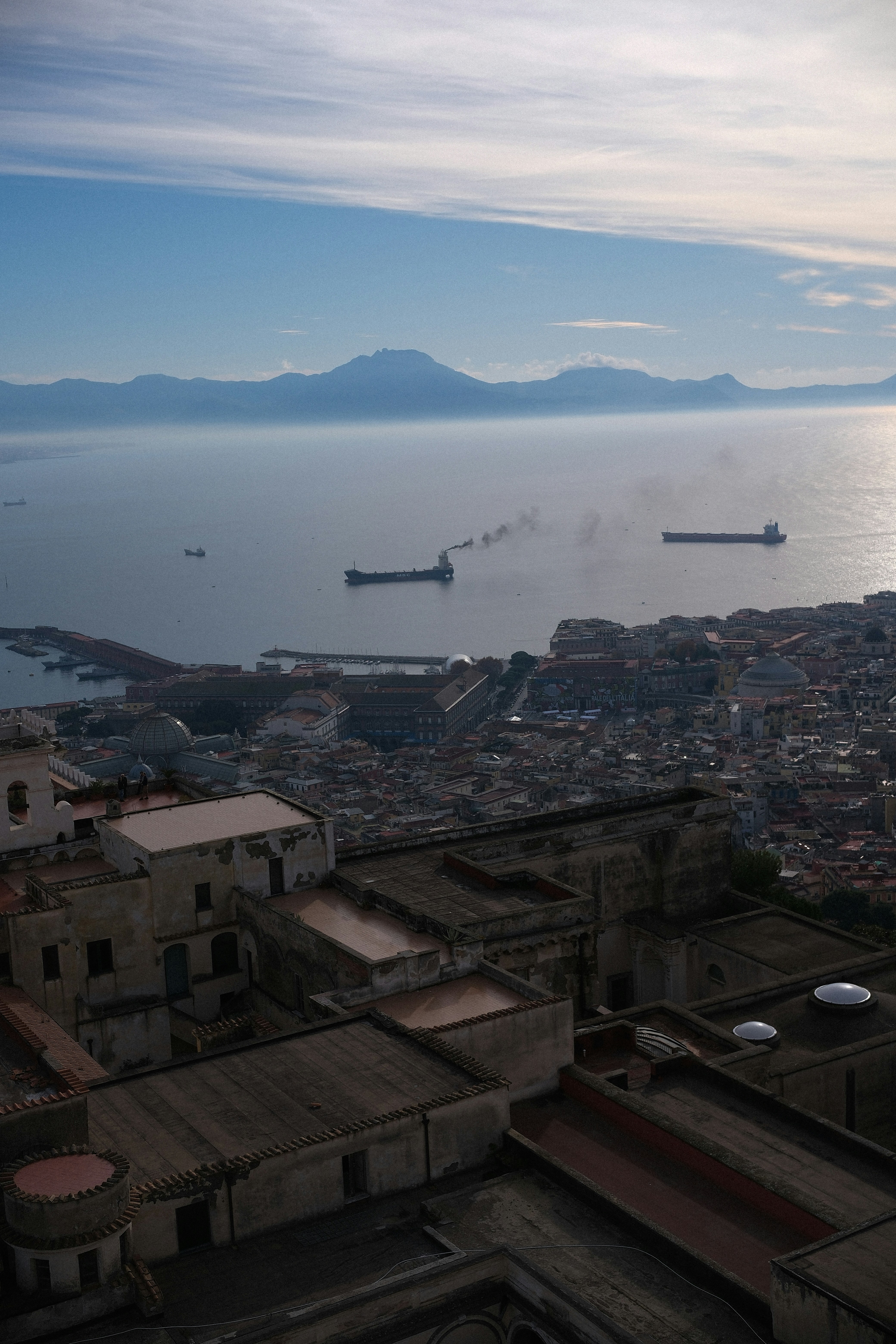 Cityscape with ships on the bay and mountains