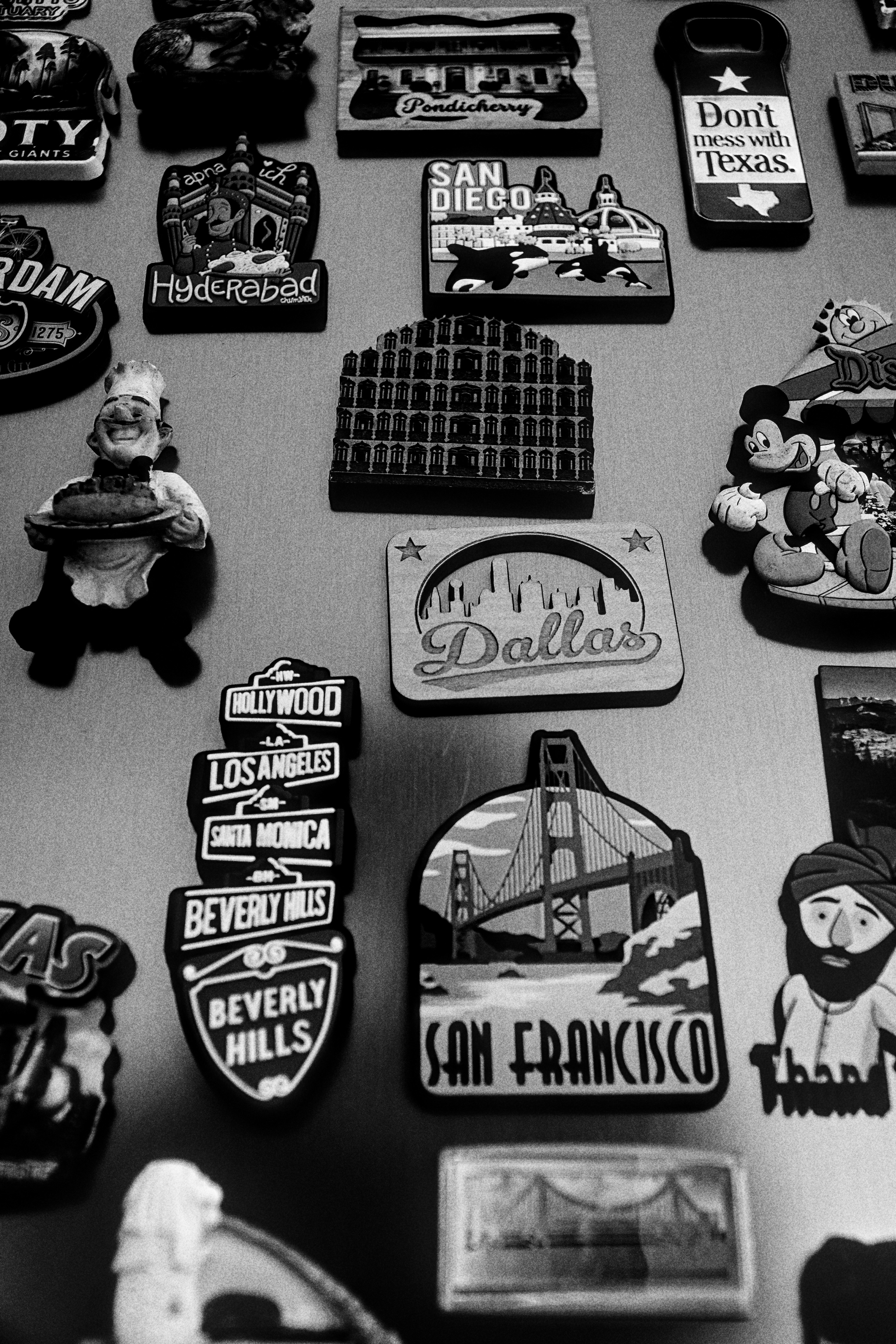 Collection of assorted travel souvenir magnets on a surface.